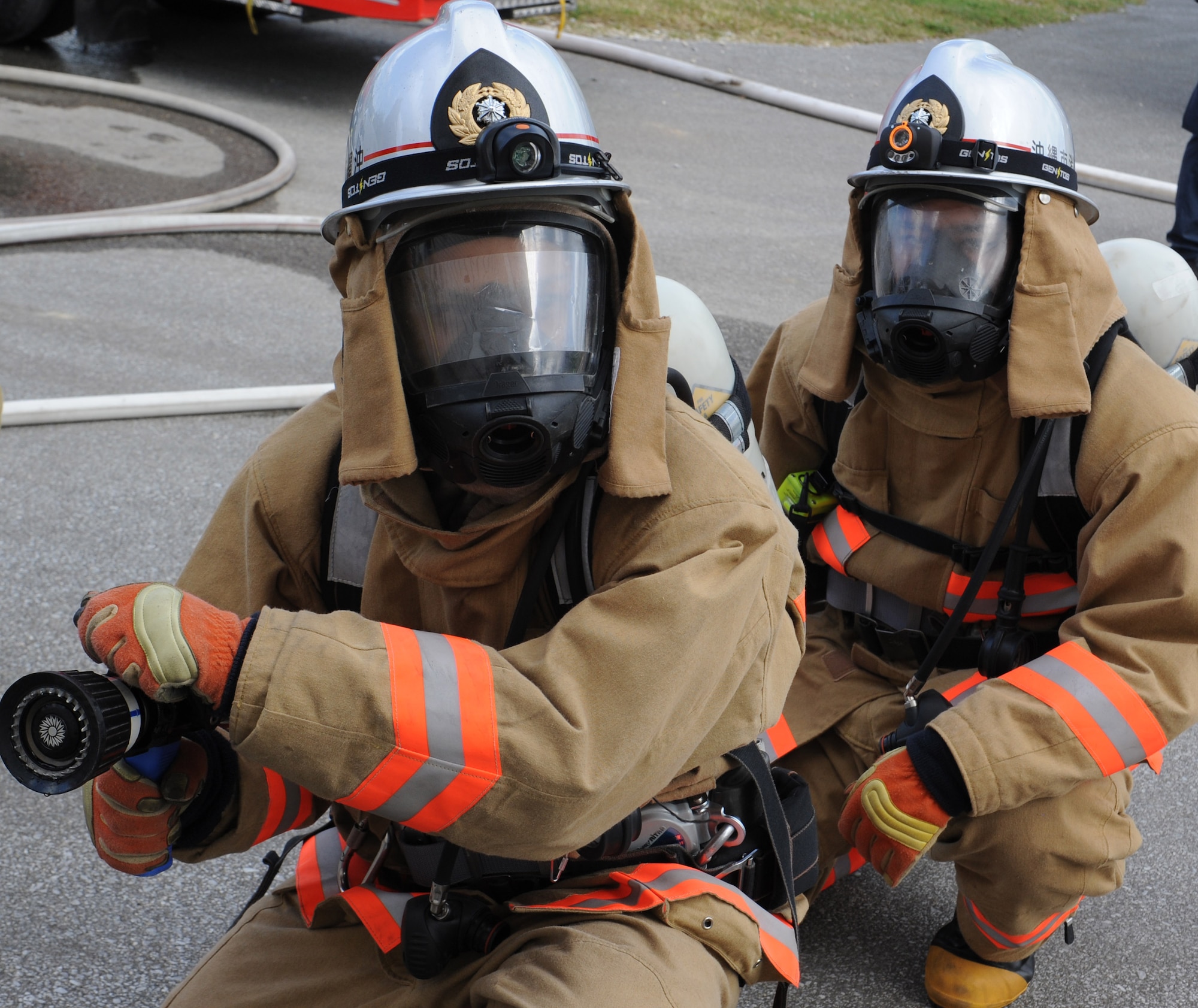 Nirai and Okinawa City firefighters prepare to enter a building during a mutual aid live fire training on Kadena Air Base, Japan, Dec. 17, 2012. Approximately 23 local-student firefighters used tactics and procedures they were taught to effectively extinguish a fire and rescue a victim. The live fire training is also a part of their mandatory annual training. (U.S. Air Force photo/Airman 1st Class Malia Jenkins)
