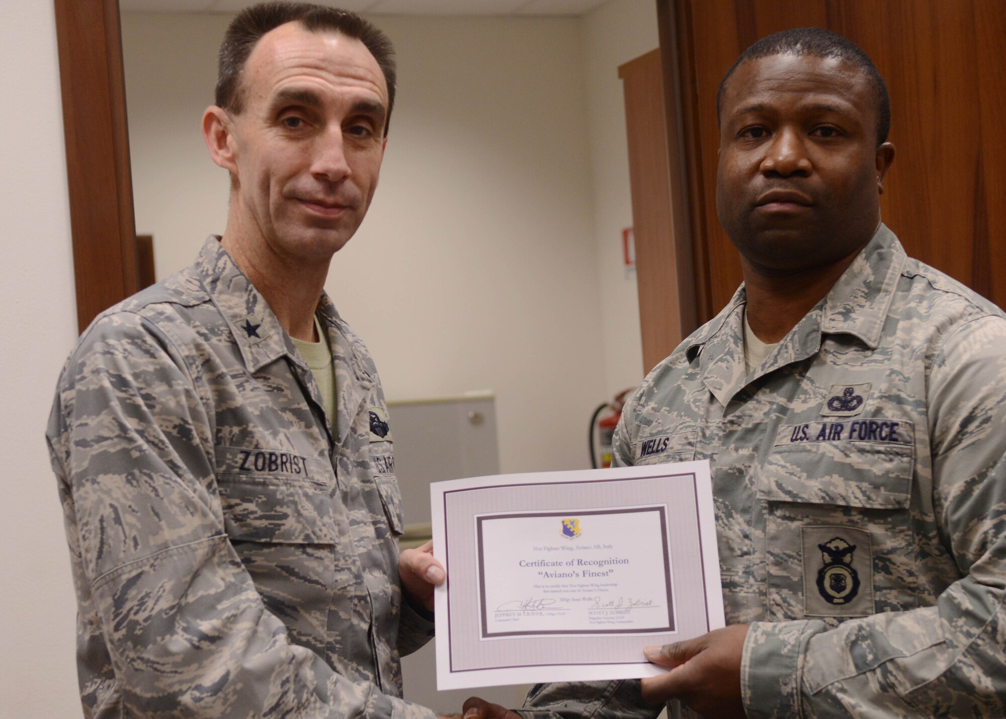 Brig. Gen. Scott J. Zobrist, 31st Fighter Wing commander, congratulate Master Sgt. Sean Wells, 31st Security Forces Squadron NCO in charge of weapons storage secuirty system, on his selection as one of Aviano's Finest. (U.S. Air Force photo/Airman 1st Class Briana Jones)
