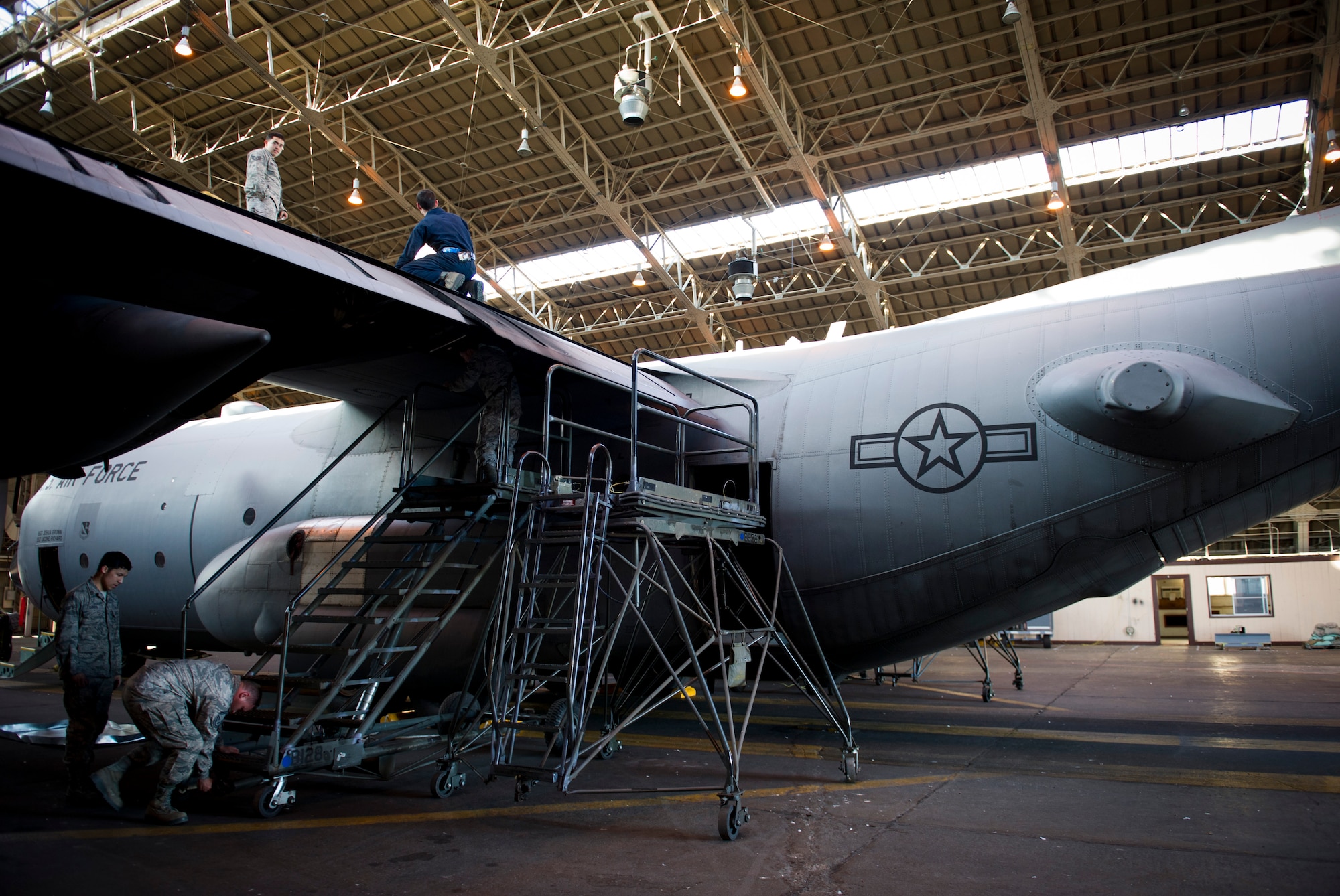 YOKOTA AIR BASE, Japan -- Crew chiefs from the 374th Aircraft Maintenance Squadron prepare to install life rafts on a C-130 Hercules aircraft at Yokota Air Base, Japan, Dec. 12, 2012.  Maintainers inspect and perform operational checks on the air craft prior to installation to ensure the aircraft and the life rafts are fully functional. (U.S. Air Force photo by Senior Airman Andrea Salazar)