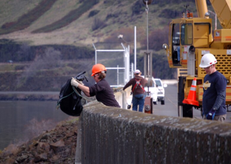 Corps of Engineers and Wash. Department of Fish and Wildlife employes dewater The Dalles Dam fish ladder. Fish remaining in the ladder are collected and returned to the Columbia River.