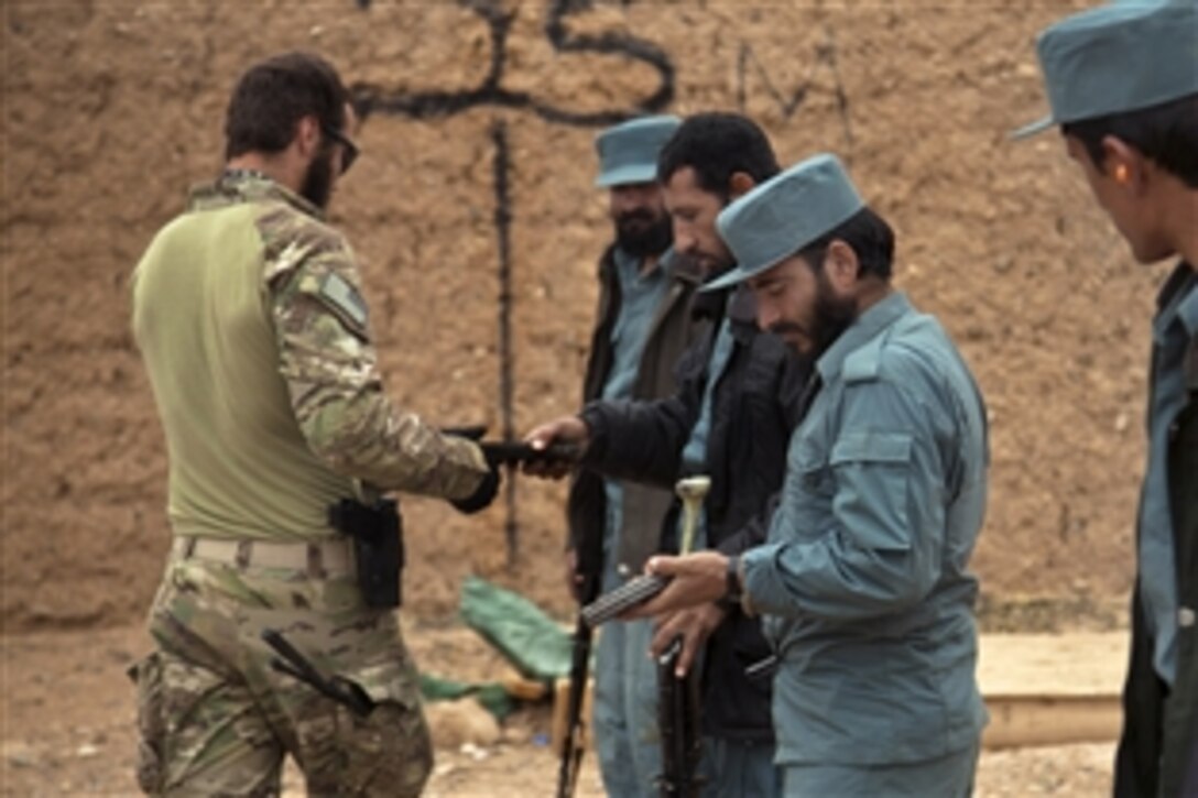 A coalition force member distributes ammunition to Afghan national police officers during weapons training in Afghanistan's western province of Farah.