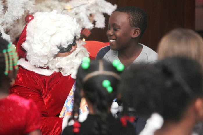 Cheddy, 10, is all smiles as he receives a gift from Santa during Marine Corps Forces Central Command 2012 Holiday Party in the Kingdom of Bahrain, Dec. 13. 