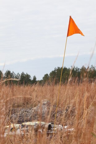 An orange flag marks a stash of obsolete ordnance destined for destruction during a demolition conducted by Ammunition Company, 2nd Supply Battalion, 2nd Marine Logistics Group aboard Camp Lejeune, N.C., Dec. 4, 2012. The company’s Marines detonated a total of 17 caches of munitions and burned a pit filled with small-arms ammunition during the training.