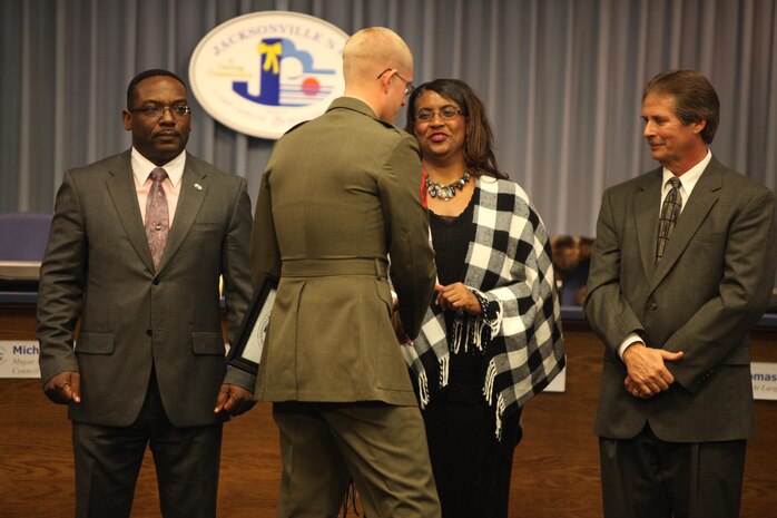 Cpl. Joshua T. Shakeshaft, a combat engineer and head instructor for improvised explosive device awareness at the Battle Skills Training School aboard Camp Lejeune, N.C., shakes hands with members of the Jacksonville, N.C., City Council after receiving an award for his work with area veterans. Shakeshaft 