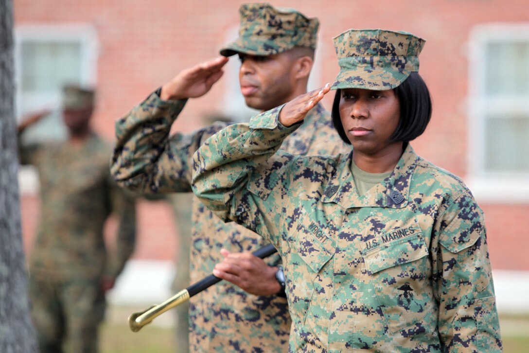Sgts. Maj. Lanette N. Wright (foreground) and Anthony L. Crutcher salute the colors during the national anthem during an appointment and relief ceremony aboard Camp Lejeune, N.C., Dec. 11, 2012.  Crutcher, the outgoing sergeant major, passed responsibilities to Wright, who will deploy with Combat Logistics Regiment 2, 2nd Marine Logistics Group at the beginning of 2013.