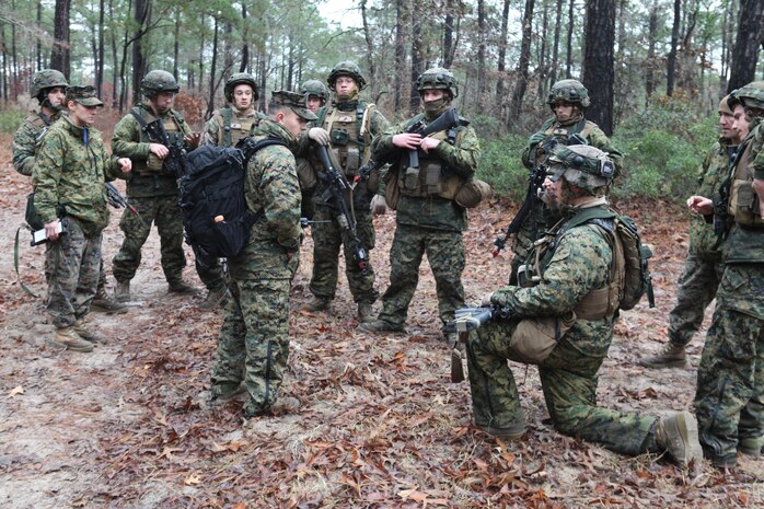 First Lt. Thomas W. Palmer (center), a platoon commander with Charlie Company, 8th Engineer Support Battalion, 2nd Marine Logistics Group, debriefs his Marines after a firefight at the unit’s training site aboard Camp Lejeune, N.C., Dec. 13, 2012. Palmer served as an observer during the battle and critiqued his Marines’ performance during their ambush of a rival platoon. 