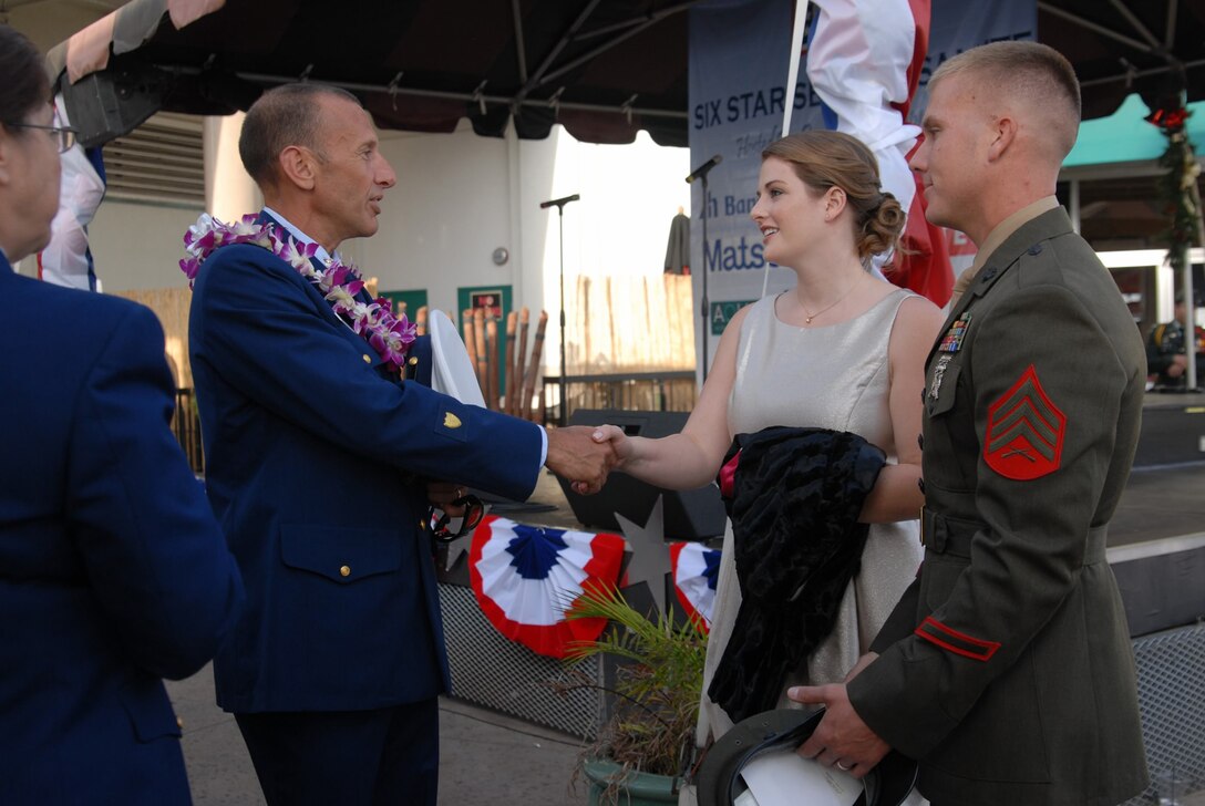 HONOLULU -  Sgt. Daniel DeJong, section leader, Bravo Company, 1st Battalion, 3rd Marine Regiment, and his wife greet a guest at the USO Service Salute, at Gordon Biersch, Dec. 1, 2012. Service members, spouses, and distinguished guests attended the USO Service Salute, which included a program and ceremony at Gordon Biersch in the Aloha Tower Marketplace, followed by an evening cruise on the Star of Honolulu. DeJong and Petty Officer 3rd Class Andrew Tamez, a corpsman with Headquarters and Service Company, 1st Bn., 3rd Marines, were among the honorees chosen this year by the USO. (Official U.S. Marine Corps photo by Kristen Wong)