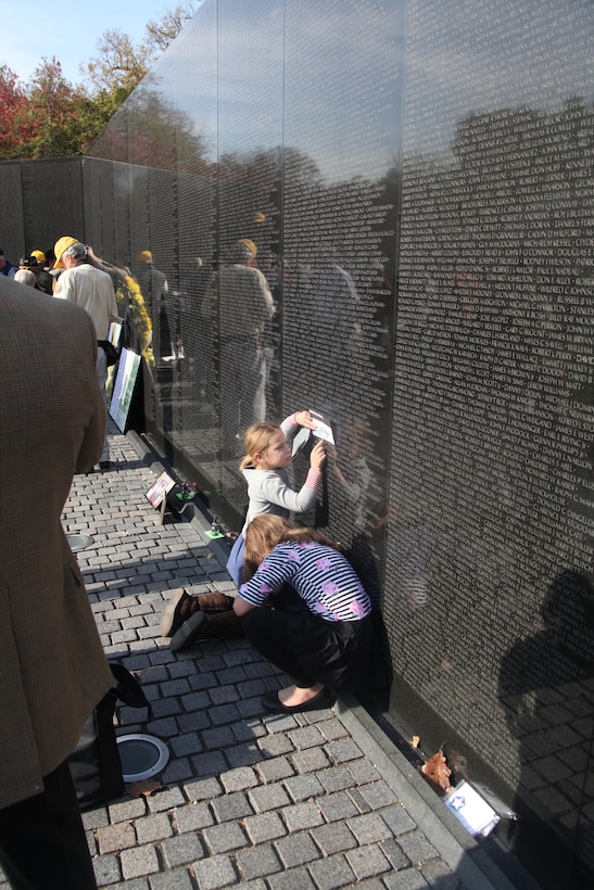 A young girl stencils the name of a fallen warrior from the Vietnam Memorial in Washington D.C. Nov. 10. Visitors can stencil any name on the wall as a souvenir. 