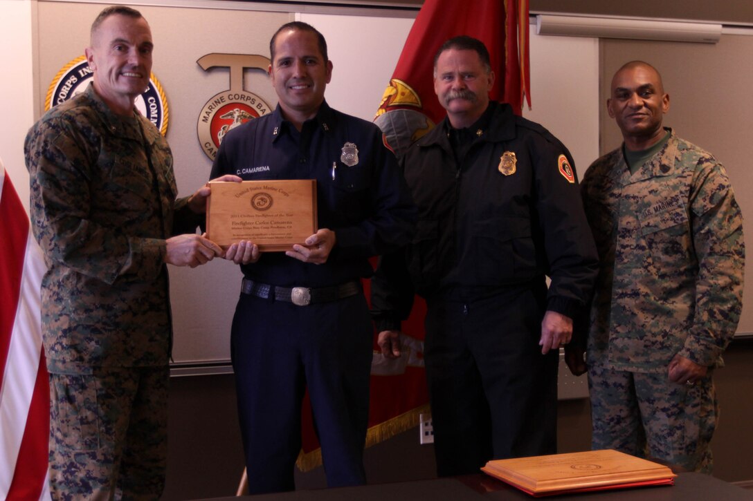 Brig. Gen. Vincent Coglianese, left, poses with Capt. Carlos Camarena, center-left, Fire Chief Thomas Thompson, center-right, and Sgt. Maj. Derrick Christovale Sr., right, after presenting Camarena with the 2011 Firefighter of the Year Award here Dec. 19. Camarena is a civilian firefighter here, Thompson is the chief of Fire and Emergency Services here. Coglianese is the base commanding general and regional authority for five military installations in the Southwestern United States and Christovale is the senior enlisted advisor.