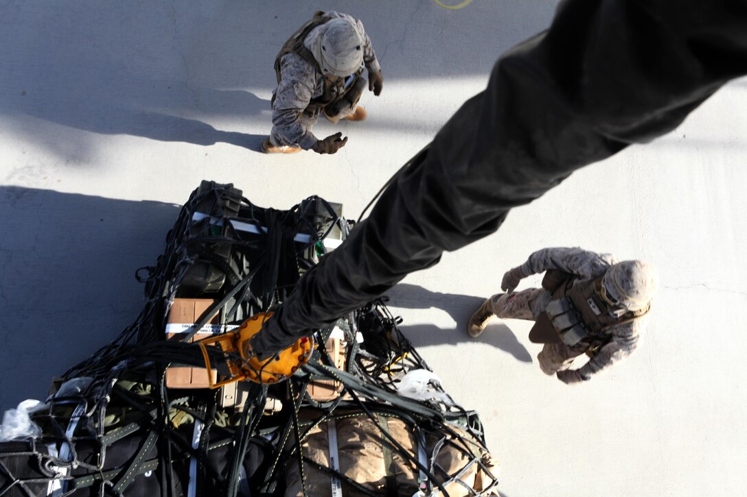 Marines with the 5th Marine Regiment connect a cargo net filled with supplies to a single hook to be lifted externally by a CH-53E Super Stallion during an external lift exercise aboard Marine Corps Air Ground Combat Center Twentynine Palms, Calif., Dec. 5. External lifts can use up to two cables to ensure the load is steady and centered.