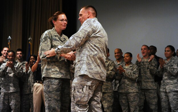 Col. Johnny Roscoe, 15th Wing commander, shakes the hand of Staff Sgt. Simona Patrick, 647th Force Support Squadron, during a step-promotion at the 15th WG commander's call at the base theater Dec. 18 at Joint Base Pearl Harbor-Hickam, Hawaii. Patrick was the only staff sergeant selected through the "Stripes for Exceptional Performers," or "STEP" program this year from a pool of nearly 900 other staff sergeants from the 15th Wing and 647th Air Base Group. (U.S. Air Force photo by Staff Sgt. Nathan Allen)