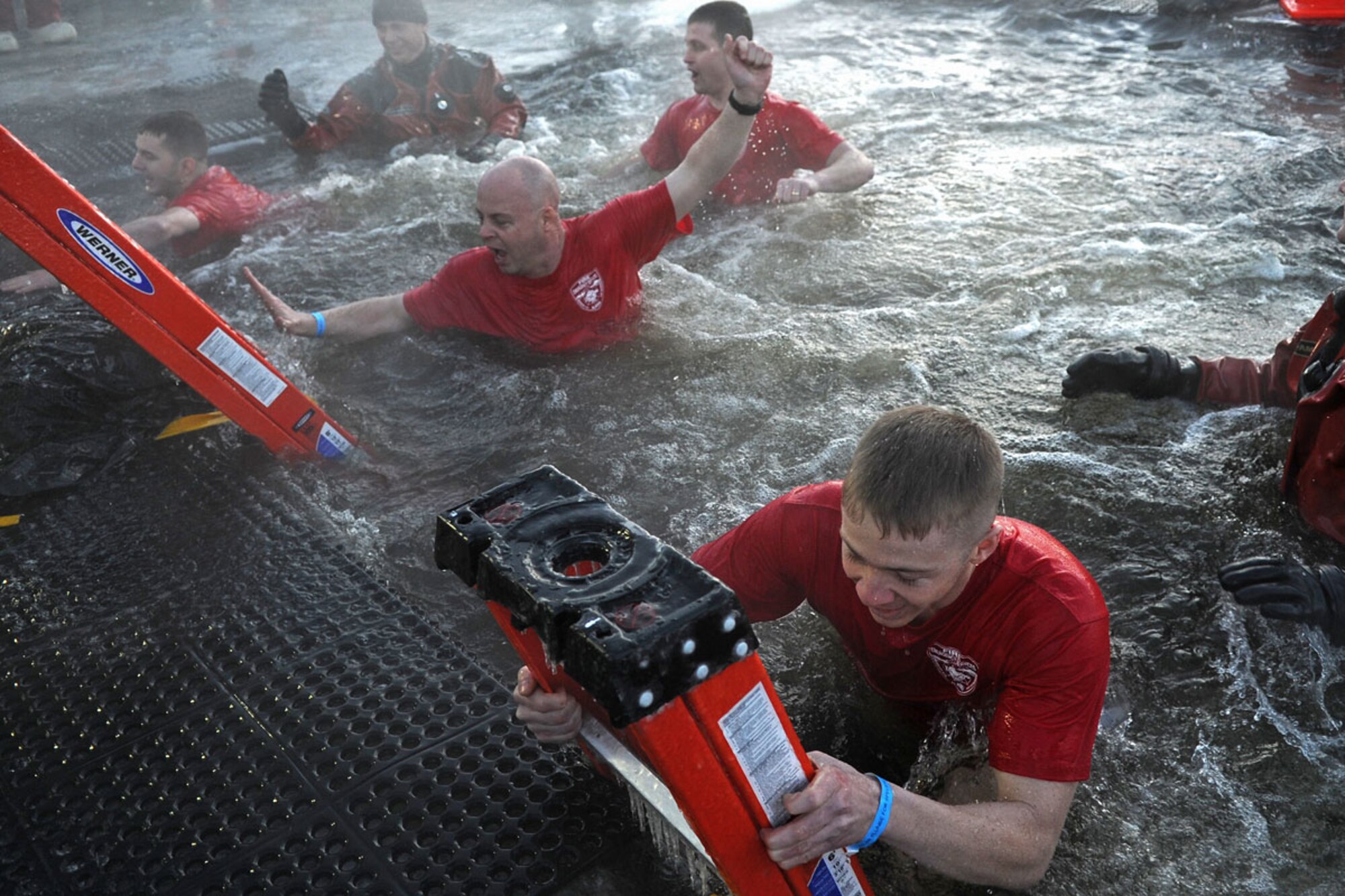 Members of the Joint Base Elmendorf-Richardson Fire Department participate in Polar Plunge 2012, Dec. 15. The Polar Plunge supports Special Olympics Alaska athletes by gathering pledges and jumping or running into the icy waters of Goose Lake in Anchorage, Alaska. So far the event has raises more than $377,000. (U.S. Air Force photo/Tech Sgt. Brian Ferguson)