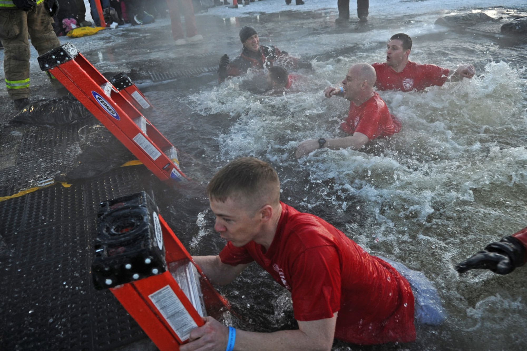 Members of the Joint Base Elmendorf-Richardson Fire Department participate in Polar Plunge 2012, Dec. 15. The Polar Plunge supports Special Olympics Alaska athletes by gathering pledges and jumping or running into the icy waters of Goose Lake in Anchorage, Alaska. So far the event has raises more than $377,000. (U.S. Air Force photo/Tech Sgt. Brian Ferguson)
