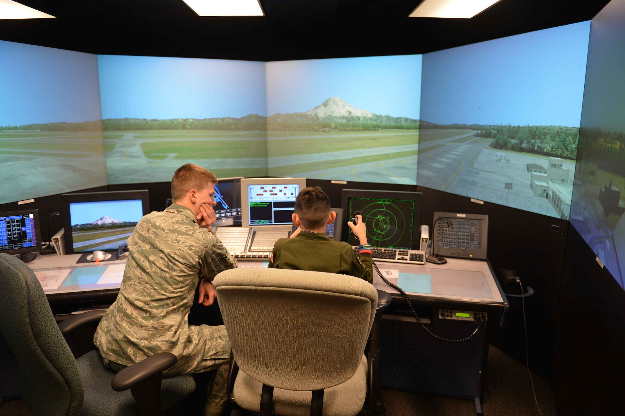 Senior Airman Logan Williams, 62nd Operations Support Squadron air traffic controller, shows Tommy McGraw how to communicate with aircraft Dec. 17, 2012 at Joint Base Lewis-McChord, Wash. Tommy was part of the Pilot for the Day program, an Air Force program that enables challenged youth to visit an Air Force base. (U.S. Air Force photo/Staff Sgt. Jason Truskowski)