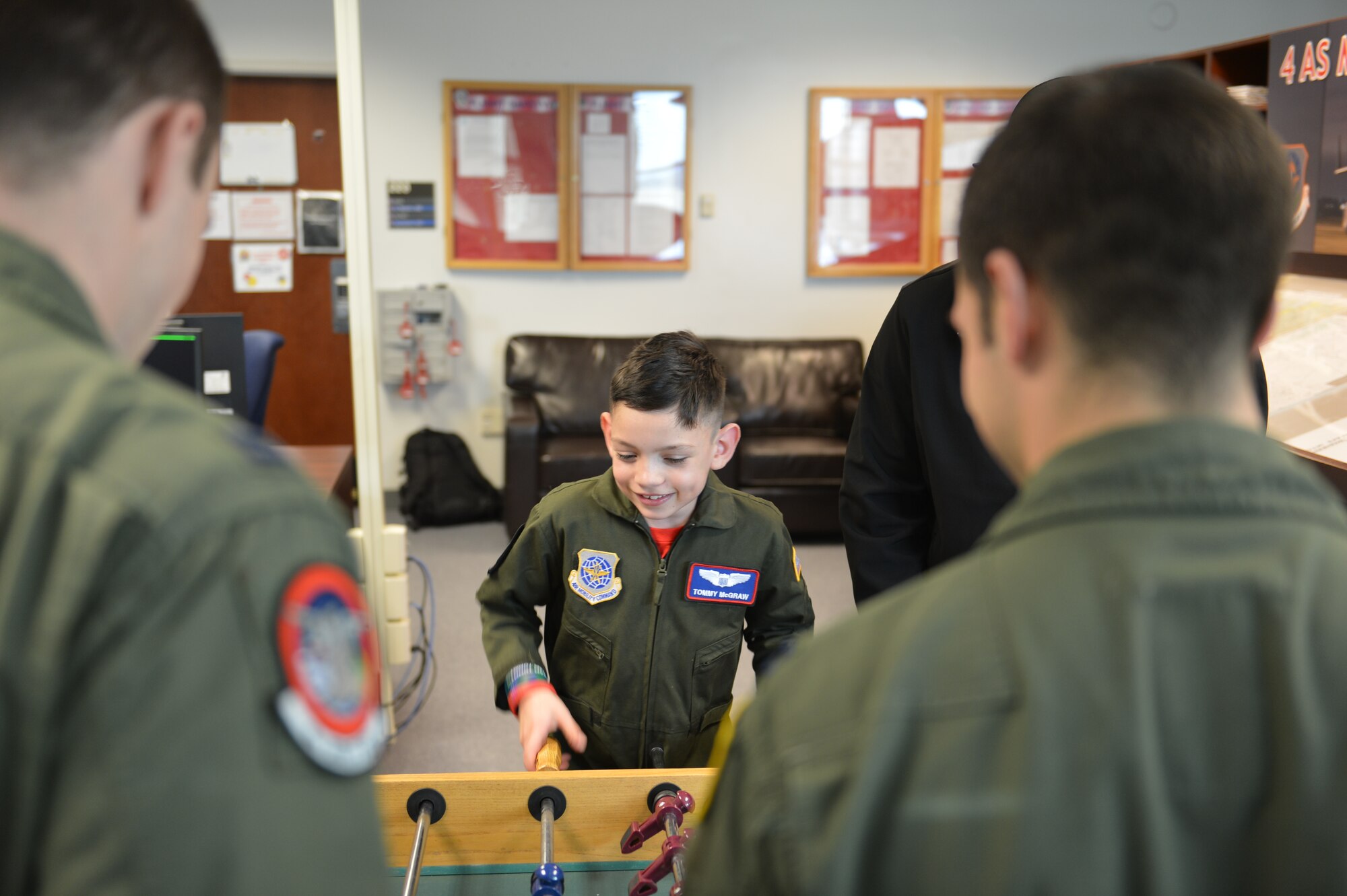 Tommy McGraw plays table football with members of the 4th Airlift Squadron Dec. 17, 2012, during lunch at Joint Base Lewis-McChord, Wash. The 4th AS hosts the Pilot for a Day program an average of six times a year. (U.S. Air Force photo/Staff Sgt. Jason Truskowski)