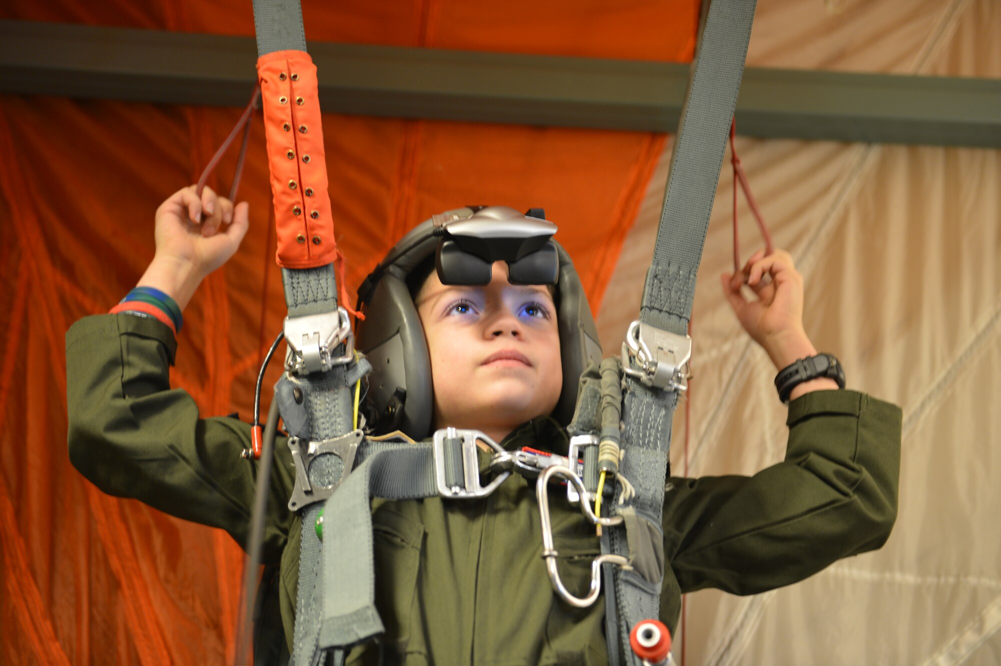 Tommy McGraw hangs in the harness of a parachute simulator Dec. 17, 2012, at Joint Base Lewis-McChord, Wash. As part of the simulated training program, Tommy learned what aircrew members should do in case they need to jump out of an aircraft. (U.S. Air Force photo/Staff Sgt. Jason Truskowski)