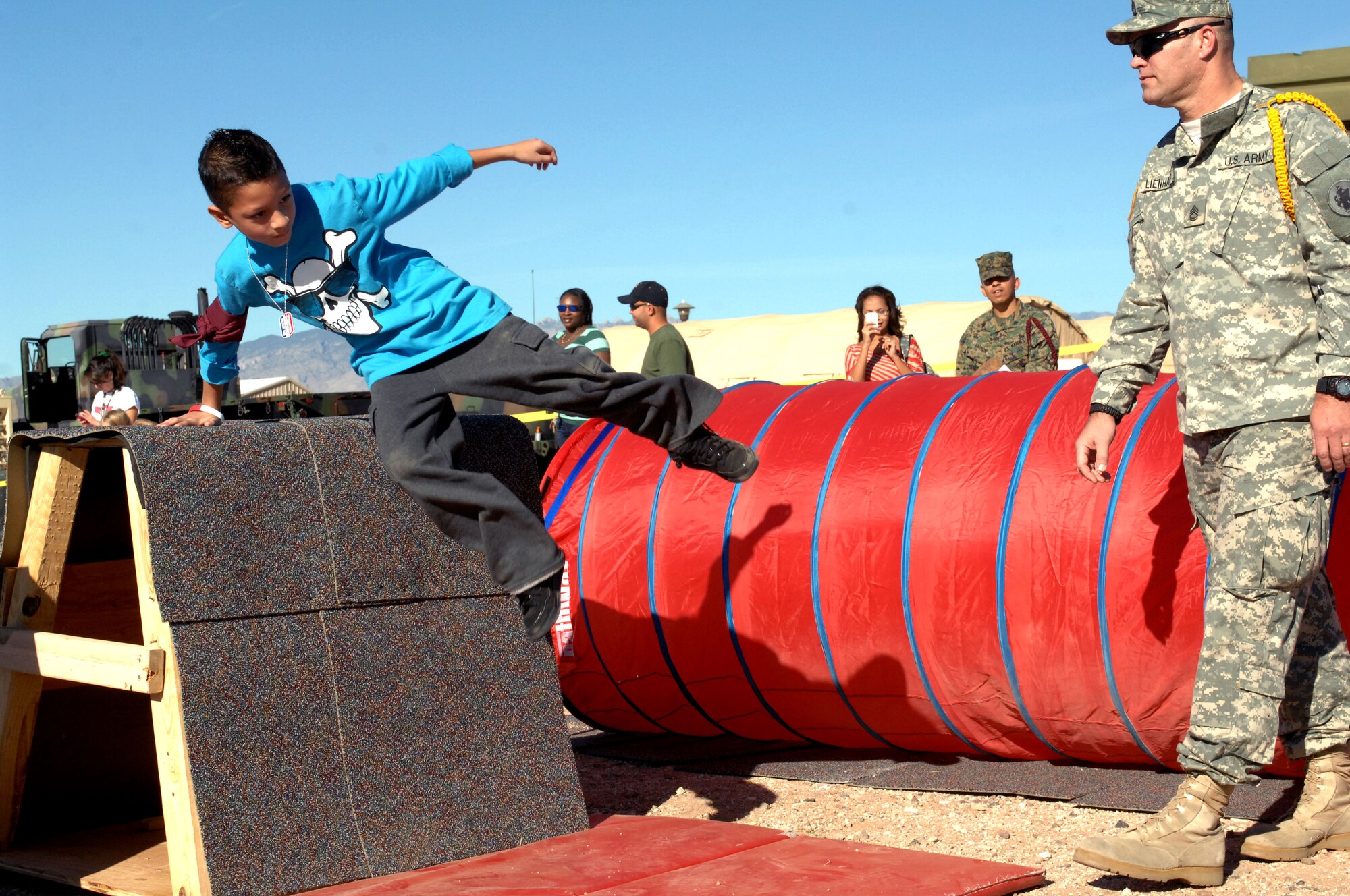 Anthony Delgado, son of U.S. Marine Corps SGT. Andres Barron, hops an obstacle at the "Boot On Boots Off" event held on Davis-Monthan Air Force Base, Ariz., Dec. 10, 2012. The course required children to scale hurtles, zig zag through poles and low crawl through tunnels.