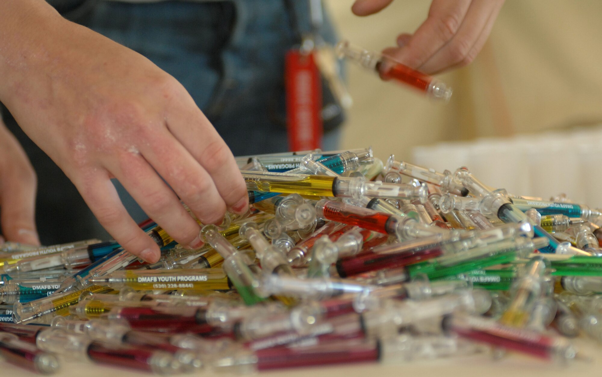 Volunteers pile candy syringes in preparations for the "Boot On Boots Off" event on Davis-Monthan Air Force Base, Ariz., Dec. 10, 2012. The event was a joint effort between the Airmen of D-M, Marines and sailors of the Tucson Naval Reserve Center and the Tucson chapter of Operation Military Kids. The children went through a mock deployment designed to give them an idea of what their parents do while deployed.