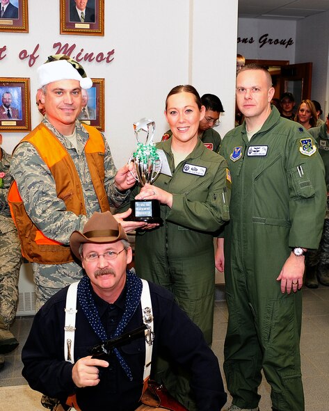 Col. Robert Vercher, 91st Missile Wing commander, poses with 2nd Lt. Jaysue Porter and Lt. Col. Christopher Cruise, both from the 742nd Missile Squadron, as they receive the travelling trophy for best decorated section here Dec. 14. The section was decorated for the 91st MW's annual Holiday Hallway Party, which provided an opportunity for all of the 91st MW units and their families to enjoy holiday cheer and share delicious food. Airmen and their families also get to visit other sections
in the wing they may have never seen before. (U.S. Air Force Photo/Airman 1st Class Kristoffer Kaubisch)
