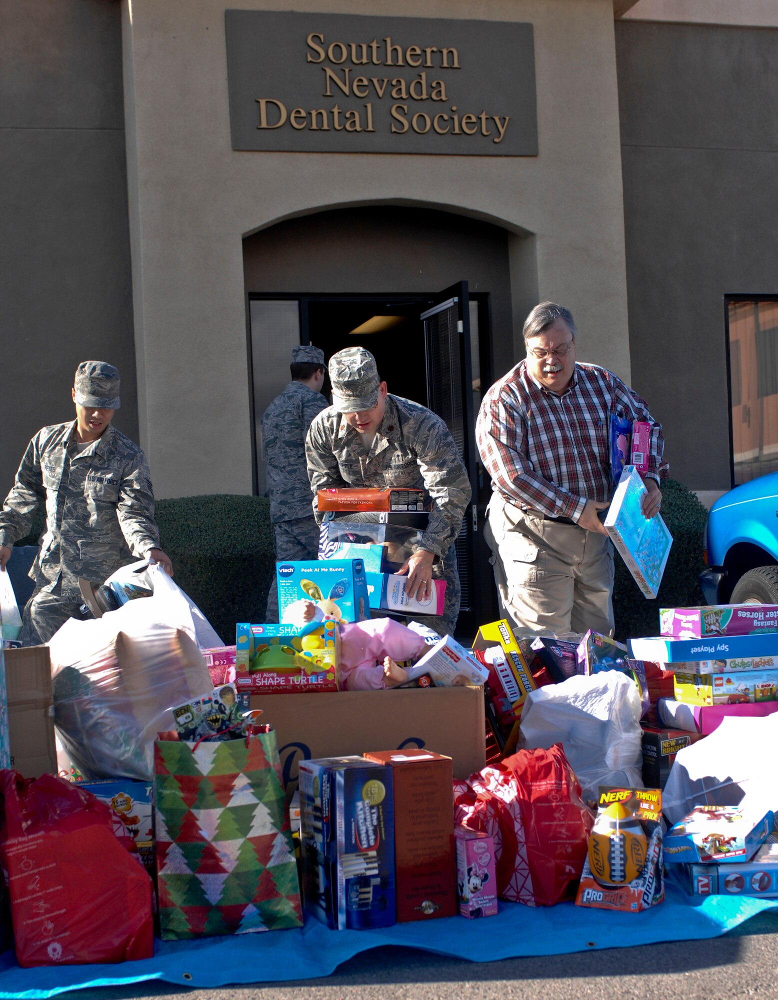 Members of the 99th Dental Squadron and the Southern Nevada Dental Society collect gifts from the Las Vegas Southern Nevada Dental Society to be taken to the 99th Dental Squadron at Nellis Air Force Base, Nev., for Operation Dental Elf Dec. 14, 2012. Gifts are dispersed to deployed service members’ families. This is the fourth year of Operation Dental Elf.(U.S. Air Force photo by Senior Airman Jack Sanders)