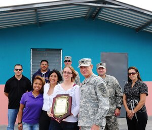 Representatives from Joint Task Force-Bravo pause for a photo in front of one of the houses they helped construct over five weeks after the ribbon cutting ceremony November 28, 2012. More than 100 servicemembers volunteered time to build 14 houses in the community of Cane, Honduras near Soto Cano Air Base.(U.S. Air Force photo/Capt. Rebecca Heyse)