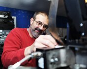 Mark Montville prepares the places the "Star Spangled Banner" reel on the projection machine.  Each reel contains about 20 minutes of content.  The role of the projectionist is to prepare a film to play seamlessly.  (U.S. Air Force photo/Staff Sgt. Maria Bowman)