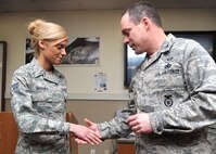 MINOT AIR FORCE BASE, N.D. - Senior Airman Bryenna Brooks, from the 2nd Aerospace Medicine Squadron at Barksdale AFB, La., and one of the Air Force's Twelve Outstanding Airmen of the Year, receives a coin from Col. Kevin Cullen, 91st Security Forces Group commander, during a meet and greet here Dec. 13. Brooks, recipient of a Purple Heart, is touring bases throughout the Air Force to talk about possible changes to help benefit Airmen. (U.S. Air Force photo/ Airman 1st Class Andrew Crawford)