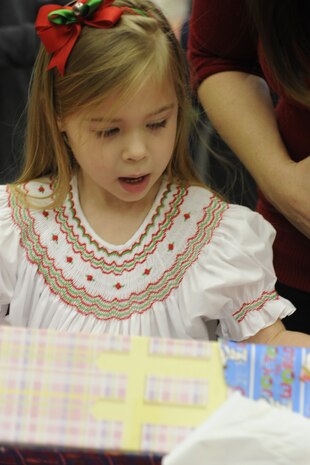 Madison Zujus, 4-year-old daughter of 1st Lt. Joseph Zujus, 14th Airlift Squadron, unwraps her present Dec. 15, 2012, during the third Annual Deployed Children’s Holiday Party hosted by the Team Charleston Honorary Commander’s Advisory Council at Joint Base Charleston – Air Base, S.C.  (U.S. Air Force photo/ Master Sgt. Maria Bare)