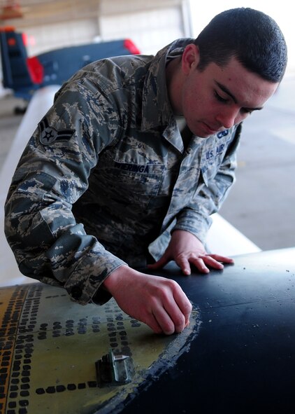 Airman 1st Class Joshua Wieringa, 9th Aircraft Maintenance Squadron crew chief, scrapes sealant from an Air Force RQ-4 Global Hawk intelligence, surveillance and reconnaissance aircraft at Dec. 19, 2012, at Beale Air Force Base, Calif. After the sealant was removed, the forward nacelle air intake was installed.  (U.S. Air Force photo by Senior Airman Shawn Nickel/Released)