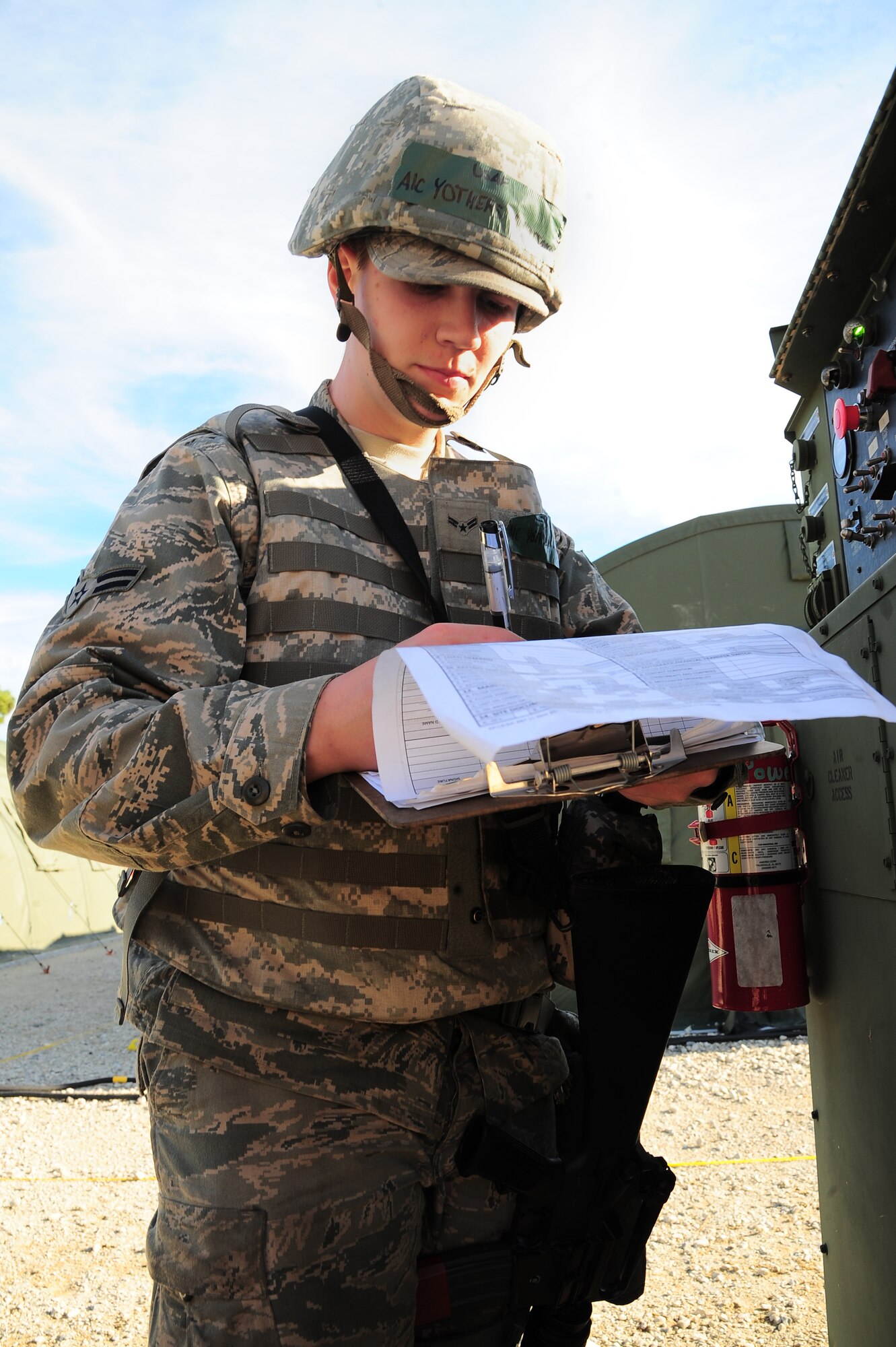 U.S. Air Force Airman 1st Class Benjamin Yothers, 4th Civil Engineer Squadron power production journeyman, records data during Operational Readiness Exercise Coronet Warrior 12-06, at a simulated deployed location on Seymour Johnson Air Force Base, N.C., Dec. 19, 2012. Yothers performs routine functional inspections on generators to ensure coolant  and oil pressure are at their proper levels. (U.S. Air Force photo/Airman 1st Class Aubrey White/Released)