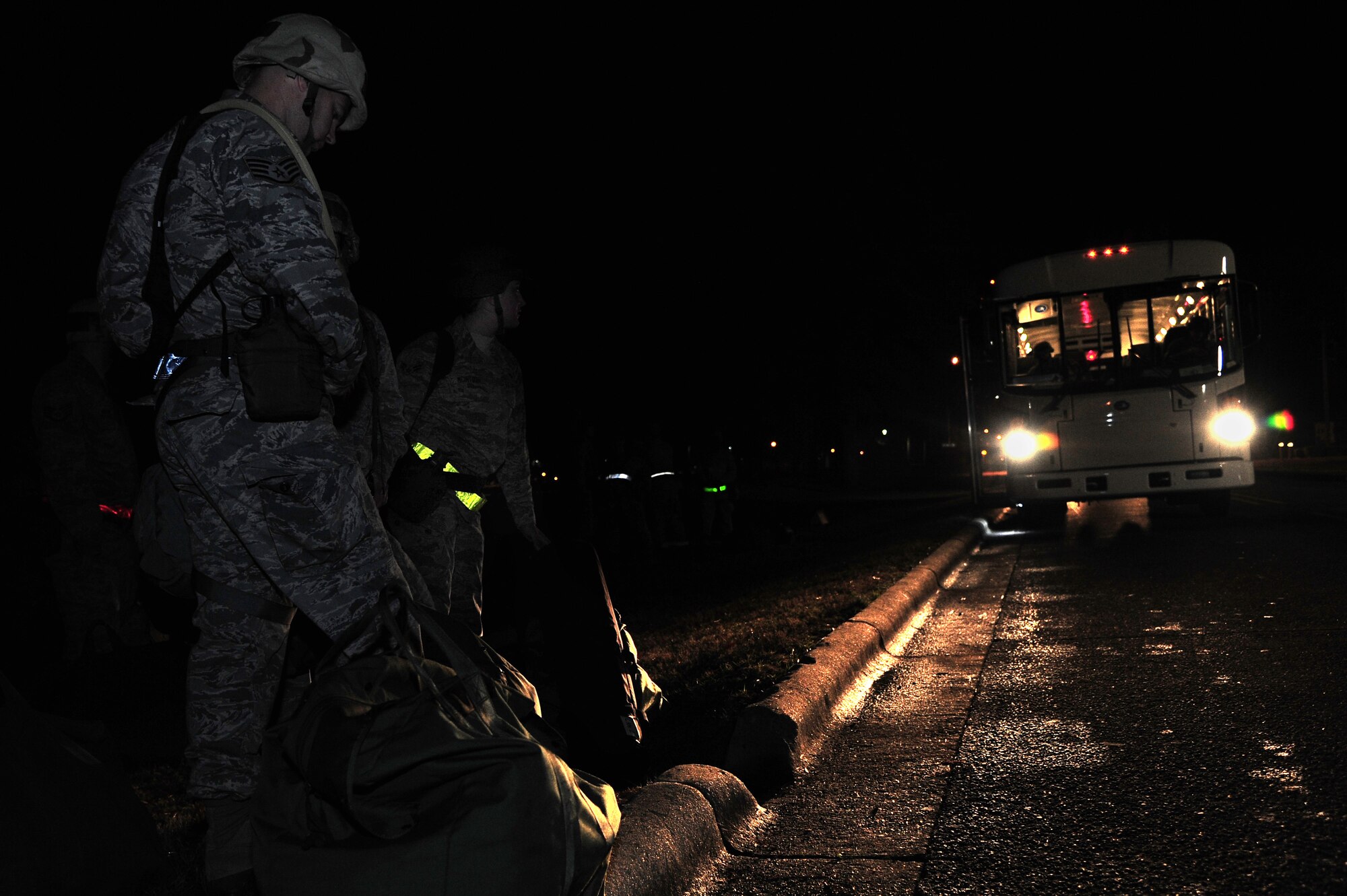 U.S. Air Force Airmen assigned to the 4th Fighter Wing wait for an oncoming bus during Operational Readiness Exercise Coronet Warrior 12-06, at a simulated deployed location on Seymour Johnson Air Force Base, N.C., Dec. 18, 2012. Airmen transitioned to Base X by bus during various hours of the day and night. (U.S. Air Force photo/Airman 1st Class Aubrey White/Released)