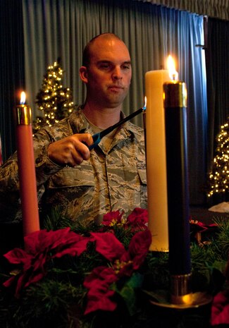 12/19/2012 - Staff Sgt. David Day, 99th Air Base Wing chaplain assistant and NCOIC of program support, lights the Advent candles at the chapel Dec. 19, 2012. The Nellis AFB Chapel holiday schedule is as follows: Protestant services include the Fourth Sunday of Advent service Dec. 23 at 8 a.m. and 11:15 a.m. and the Christmas Eve service Dec. 24 at 7 p.m. Catholic services include the Christmas Eve Mass Dec. 24 at 5 p.m., the Christmas Day Mass Dec. 25 at 9:45 a.m., the Mary Mother of God Mass Dec. 31 at 5 p.m., and the Sacrament of Reconciliation every Sunday from 4 p.m. to 4:30 p.m. (U.S. Air Force photo by Staff Sgt. Christopher Hubenthal)