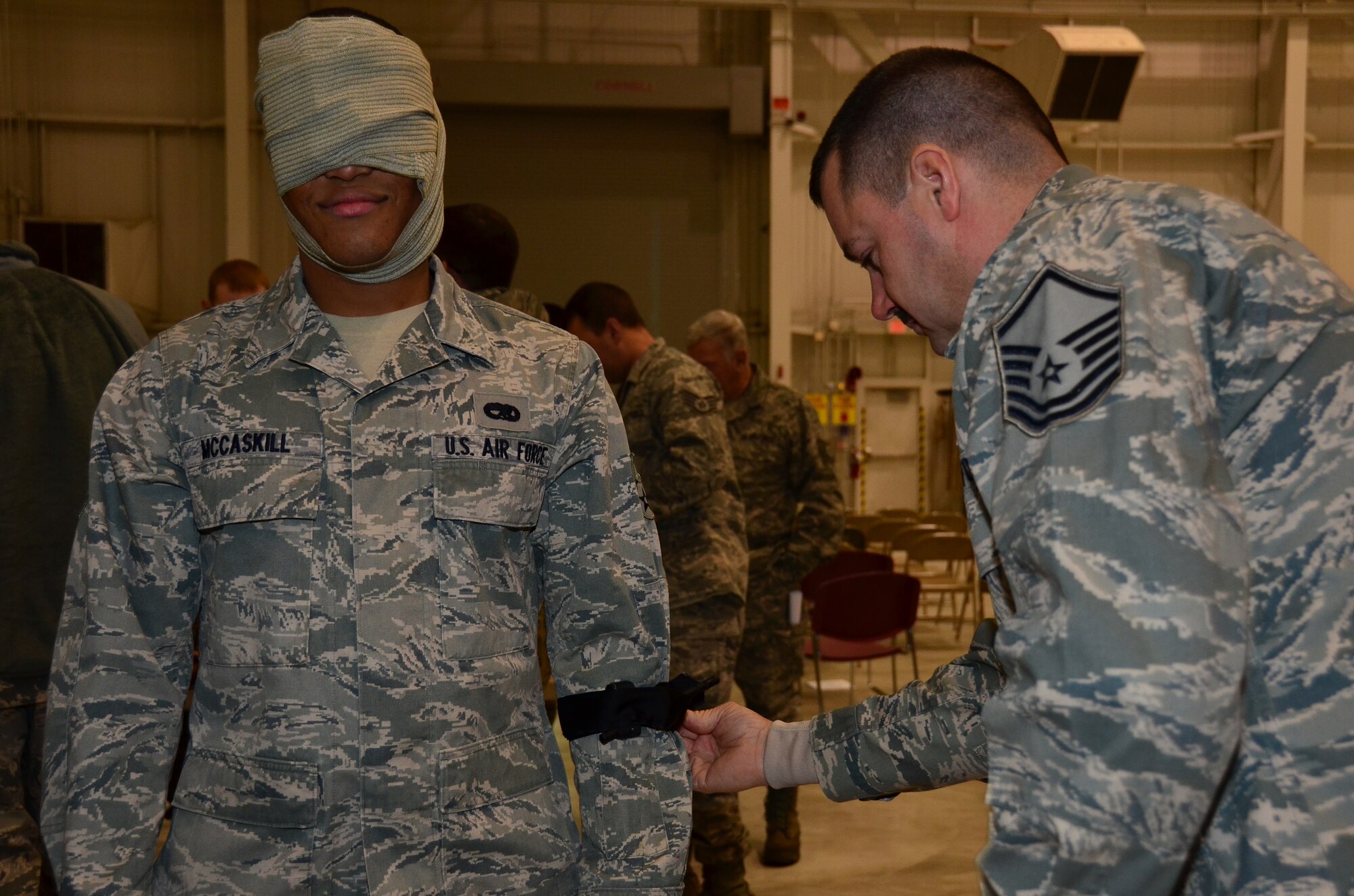 WRIGHT-PATTERSON AIR FORCE BASE, Ohio – Master Sgt. Scott Todd, 445th Aircraft Maintenance Squadron aircraft electrical and environmental systems craftsman, practices using a tourniquet on Senior Airman Alexander McCaskill, 445th AMXS aircraft maintenance journeyman, during the self aid and buddy care portion of the 445th Maintenance Group’s annual mega training Dec. 15. (U.S. Air Force photo/Staff Sgt. Amanda Duncan)