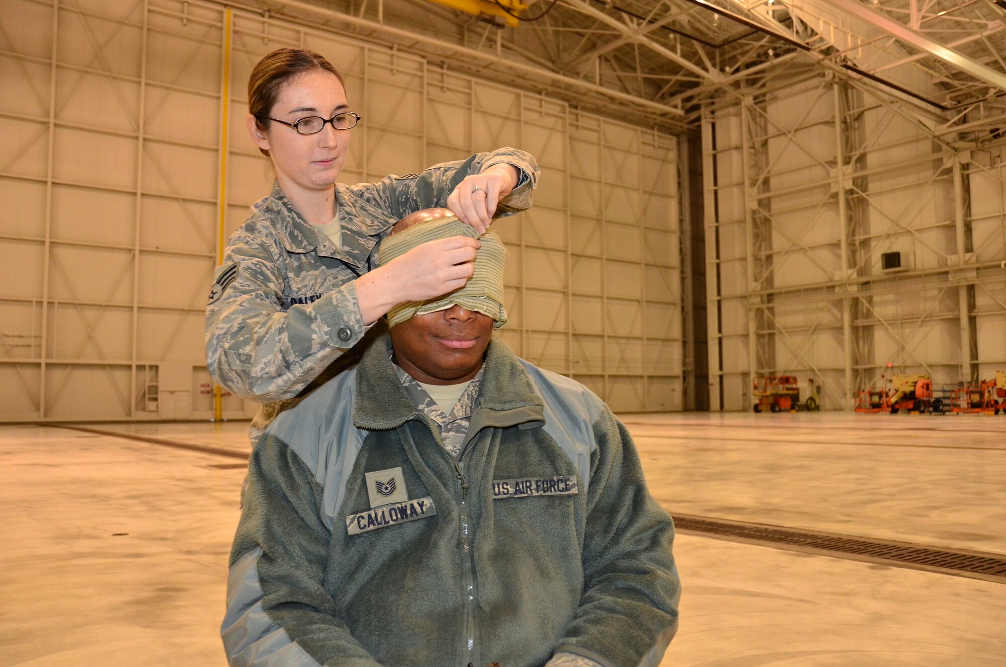 WRIGHT-PATTERSON AIR FORCE BASE, Ohio – Senior Airman Alyssa Daley, 445th Aircraft Maintenance Squadron aircraft guidance and control systems journeyman, practices wrapping a simulated head wound on Tech. Sgt. Ronnie Calloway, 445th AMXS aircraft maintenance craftsman, during the 445th Maintenance Group’s annual mega training Dec. 15. More than 150 maintainers participated in mega training that day. (U.S. Air Force photo/Staff Sgt. Amanda Duncan)