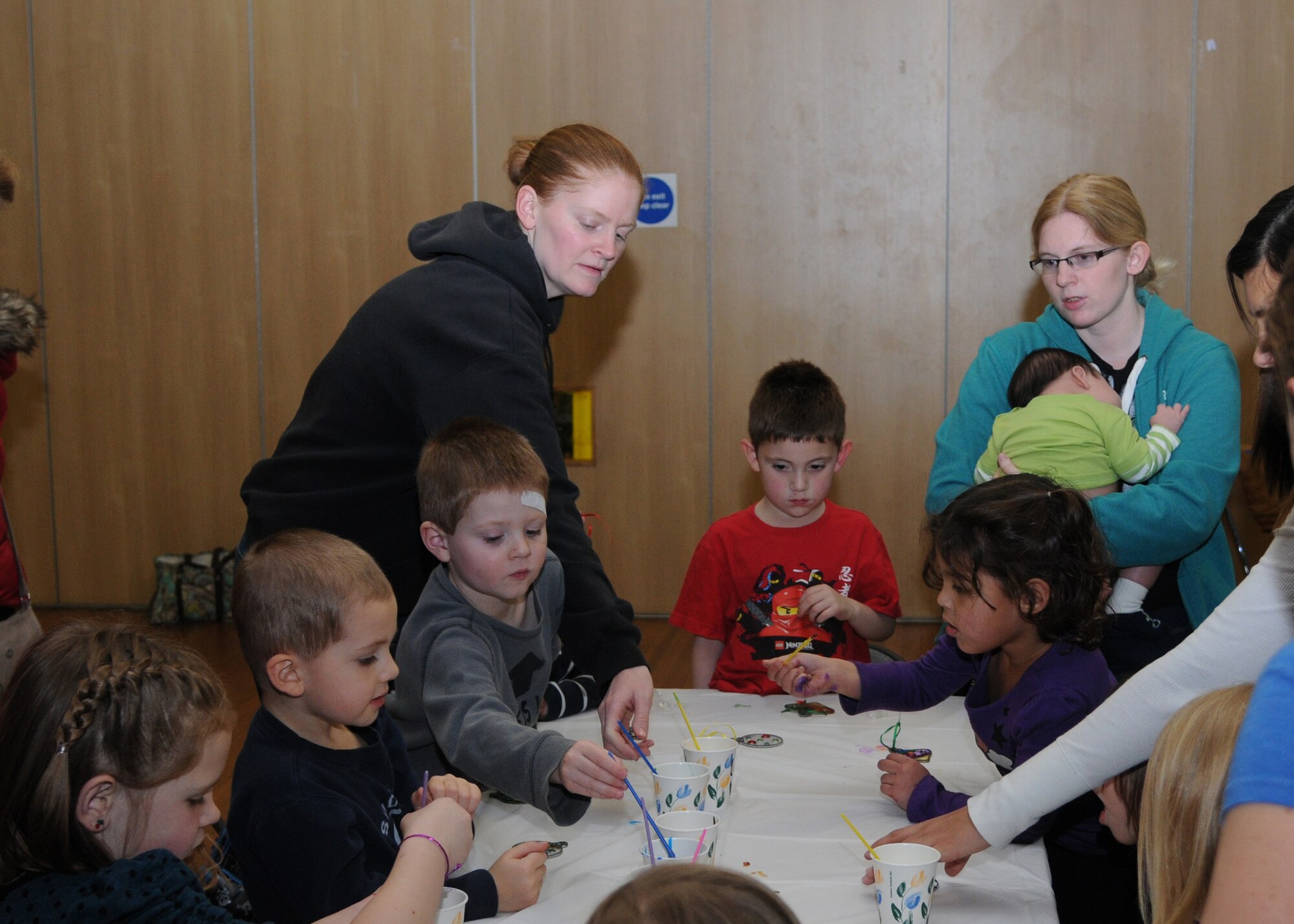 Children gather around a table to paint Christmas ornaments during a Winter Arts and Crafts party Dec. 18, 2012, at the Bob Hope Community Center at RAF Mildenhall, England. The community center hosts several kids’ craft events throughout the year. (U.S. Air Force photo by Airman 1st Class Kelsey Waters/Released)