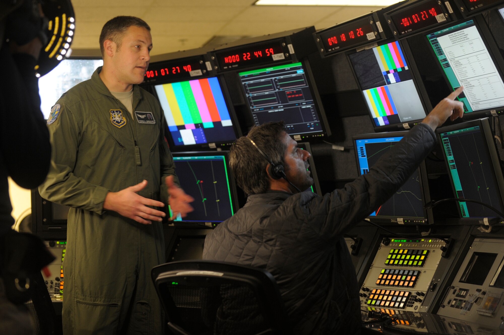 VANDENBERG AIR FORCE BASE, Calif. -- Capt. Pierre Gregoire, 2nd Range Operations Squadron operations flight commander, talks to Don Wildman, television host for the Travel Channel's show Off Limits, about range safety at the Western Range Operations Control Center here March 30, 2012. The WROCC was featured to demonstrate how the Air Force launches rockets safely. (U.S. Air Force photo/Staff Sgt. Andrew Satran) 