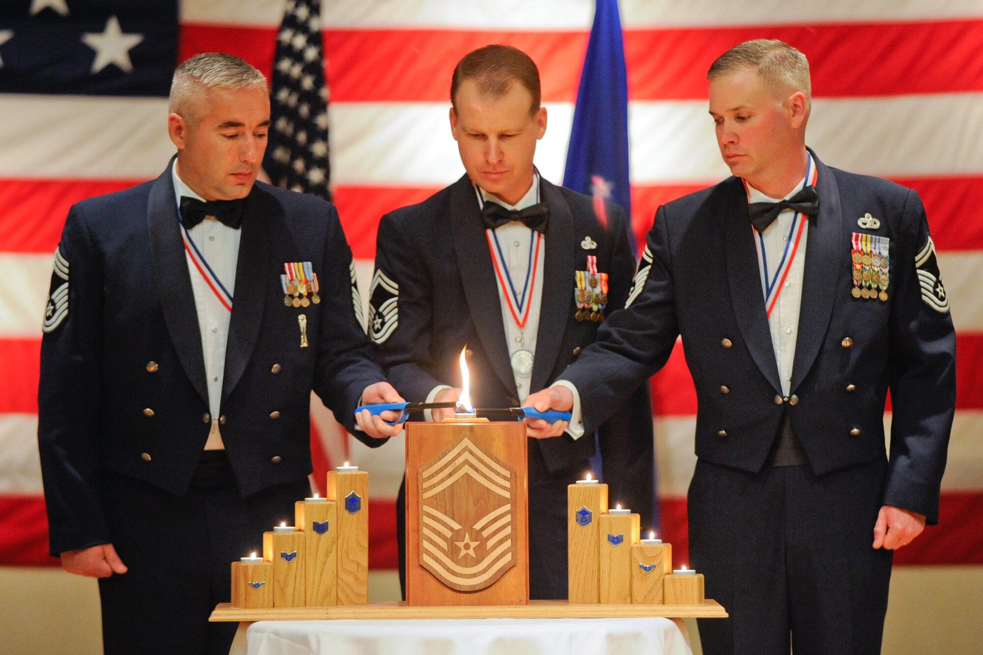 VANDENBERG AIR FORCE BASE, Calif. -- Chief Master Sgt. William Gardner, the Nation Reconnaissance Office superintendent, Senior Master Sgt. David Ovesen, the 30th Space Communications Squadron superintendent, and Senior Master Sgt. John Prather, the 30th Logistic Readiness Squadron superintendent, light a candle representing the chief master sergeant rank during Vandenberg's Annual Chief's Recognition Ceremony at the Pacific Coast Club here Saturday, March 3, 2012. This event was held to recognize Team V's newest chief selects into the highest enlisted rank in the Air Force. (U.S. Air Force photo/Staff Sgt. Levi Riendeau)