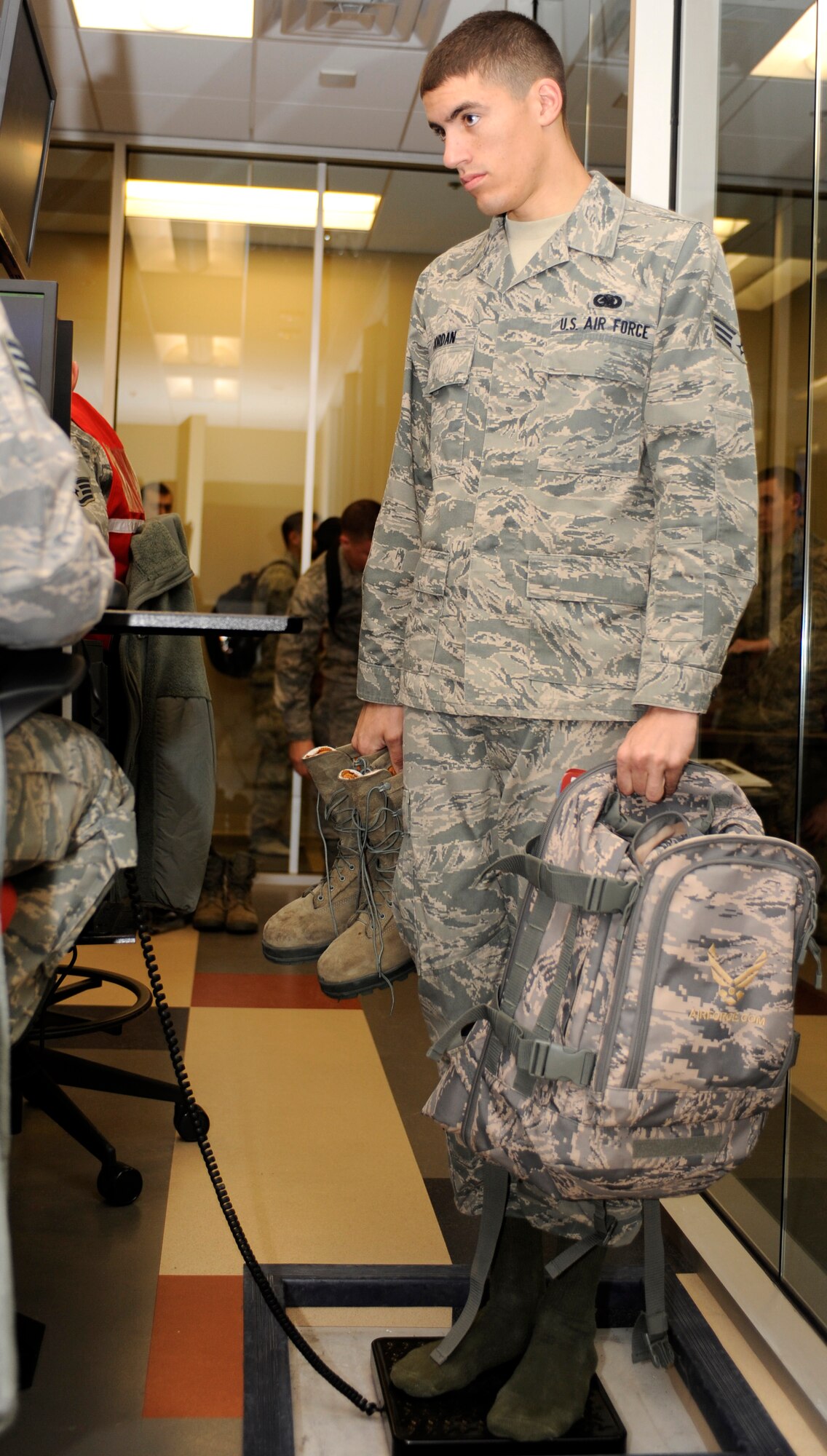 Senior Airman Joshua Jordan, 28th Logistics Readiness Squadron fuels distribution operator, stands on a scale as he verifies his personally identifiable information during a deployment readiness exercise in the Deployment Center on Ellsworth Air Force Base, S.D., Dec. 14, 2012. Airmen must be weighed while holding their carry-on luggage and other personal items to ensure the right number of people and amount of equipment is being transported during a deployment. (U.S. Air Force photo by Airman Ashley J. Woolridge/Released) 