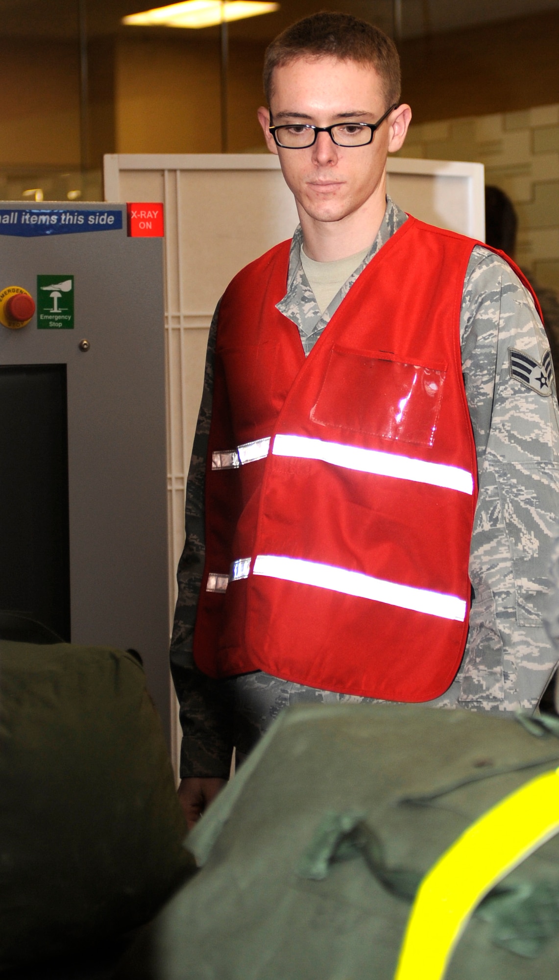 Senior Airman Christopher Redfern, 28th Logistics Readiness Squadron fuels operator, monitors baggage as it is X-rayed during a deployment readiness exercise in the Deployment Center at Ellsworth Air Force Base, S.D., Dec. 14, 2012. Baggage must be X-rayed to ensure no contraband or prohibited items such as firearms or other deadly weapons make it on board an aircraft. (U.S. Air Force photo by Airman Ashley J. Woolridge/Released)