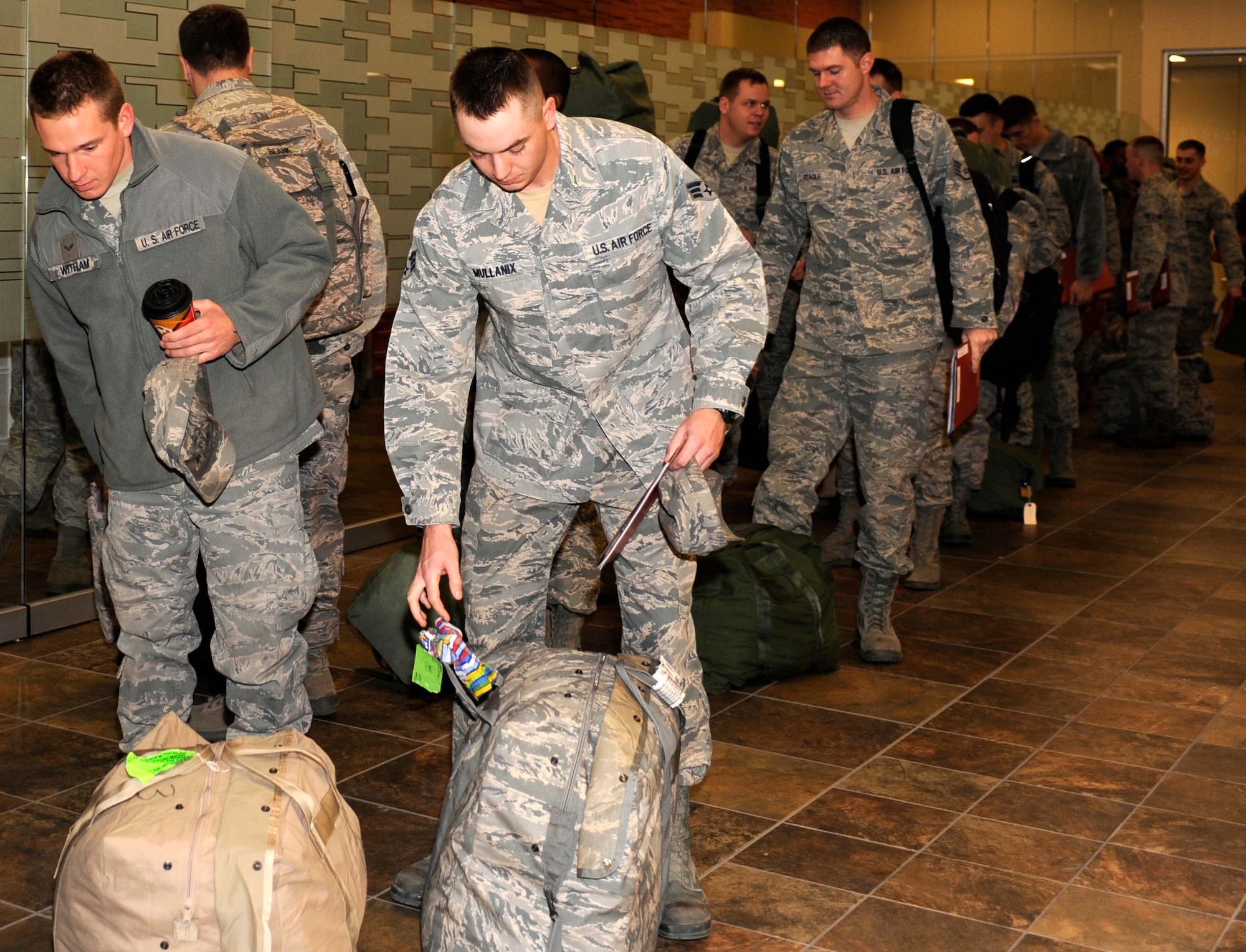 Airmen from various squadrons under the 28th Mission Support Group umbrella wait to submit their checked baggage for X-raying during a deployment readiness exercise at the Deployment Center on Ellsworth Air Force Base, S.D., Dec. 14, 2012. The 28th Logistics Readiness Squadron hosted the 28th MSG exercise in December and allowed Airmen to rehearse the mobility portion of a deployment. (U.S. Air Force photo by Airman Ashley J. Woolridge/Released) 