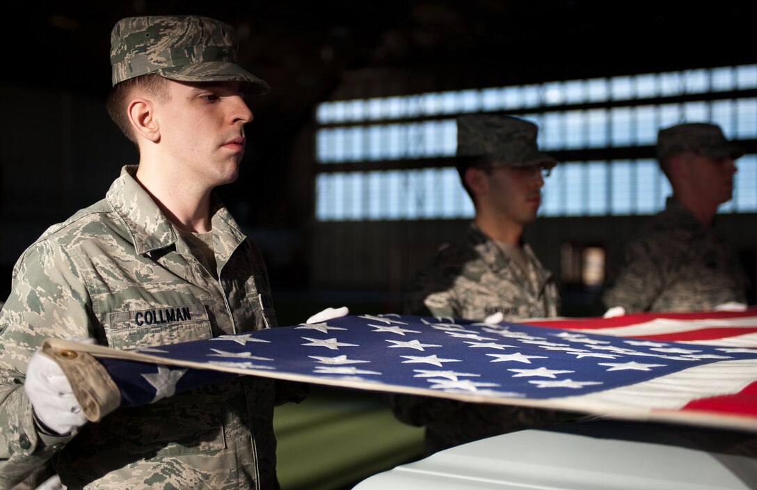 Airman 1st Class Daniel Collman, 28th Force Support Squadron base Honor Guard member, holds the corners of a U.S. flag in a tabletop position during training at Ellsworth Air Force Base, S.D., Dec. 12, 2012. The base Honor Guard is congressionally mandated to provide funeral honors for all eligible requests. (U.S. Air Force photo by Airman 1st Class Alystria Maurer/Released)