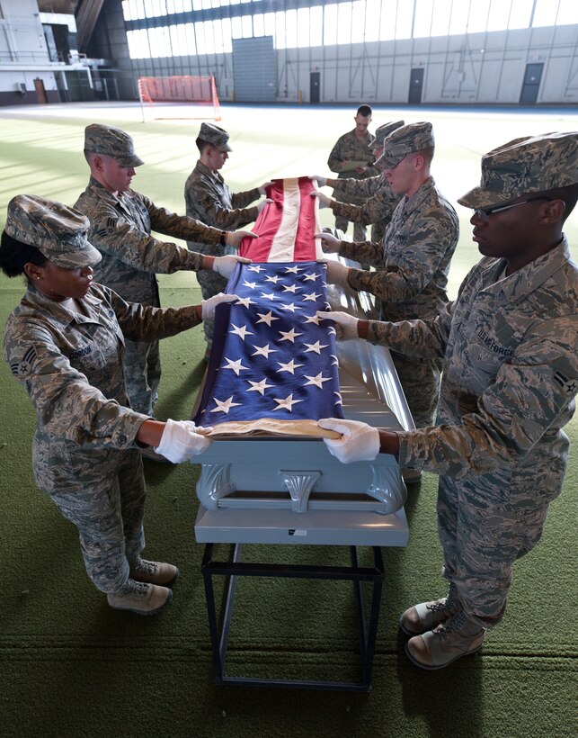 Members of the Ellsworth Honor Guard prepare to fold the U.S. flag during a training exercise at Ellsworth Air Force Base, S.D., Dec. 12, 2012. The Ellsworth Honor Guard performs military funeral honors for veterans, retirees and active-duty members, as well as color presentations and sword cordon details. (U.S. Air Force photo by Airman 1st Class Alystria Maurer/Released)