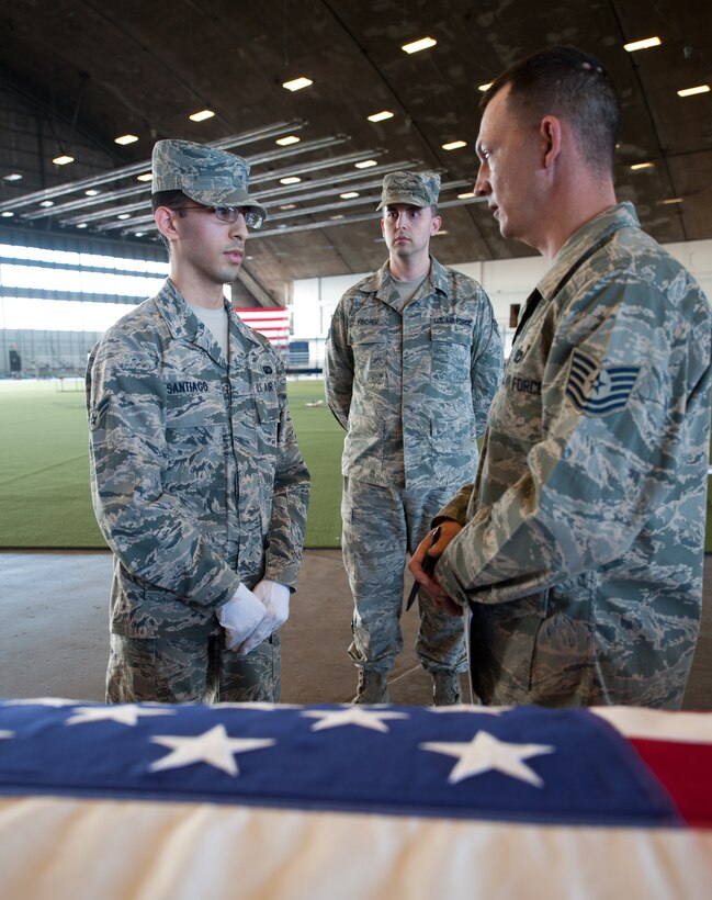 Tech. Sgt. Michael Lewis (right), 28th Force Support Squadron base Honor Guard NCO in charge, instructs Airman 1st Class Edwin Santiago (left) and Senior Airman Ward Fischer (middle), 28th FSS base Honor Guard members, during a training scenario at Ellsworth Air Force Base, S.D., Dec. 12, 2012. These Airmen were training how to properly conduct a funeral sequence in preparation for any real ceremonies. (U.S. Air Force photo by Airman 1st Class Alystria Maurer/Released)