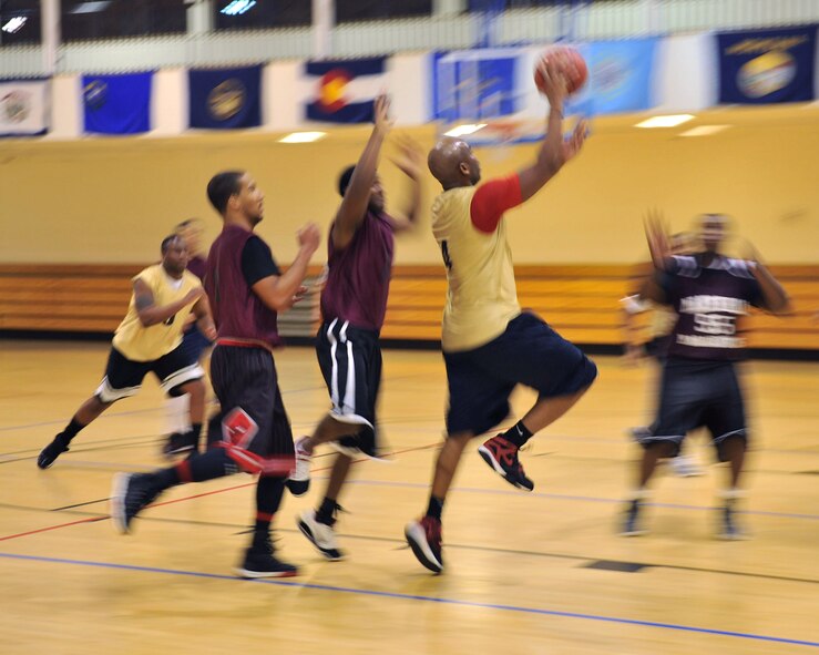 Staff Sgt. Christopher Bourand, 100th Communications Squadron information technology asset management supervisor from Miami, drives the ball toward the basket Dec. 18, 2012, at the Hardstand Fitness Center at RAF Mildenhall, England. The 100th CS challenged the 100th Security Forces Squadron in the first game of the base intramural basketball season. (U.S. Air Force photo by Senior Airman Jerilyn Quintanilla/Released)
