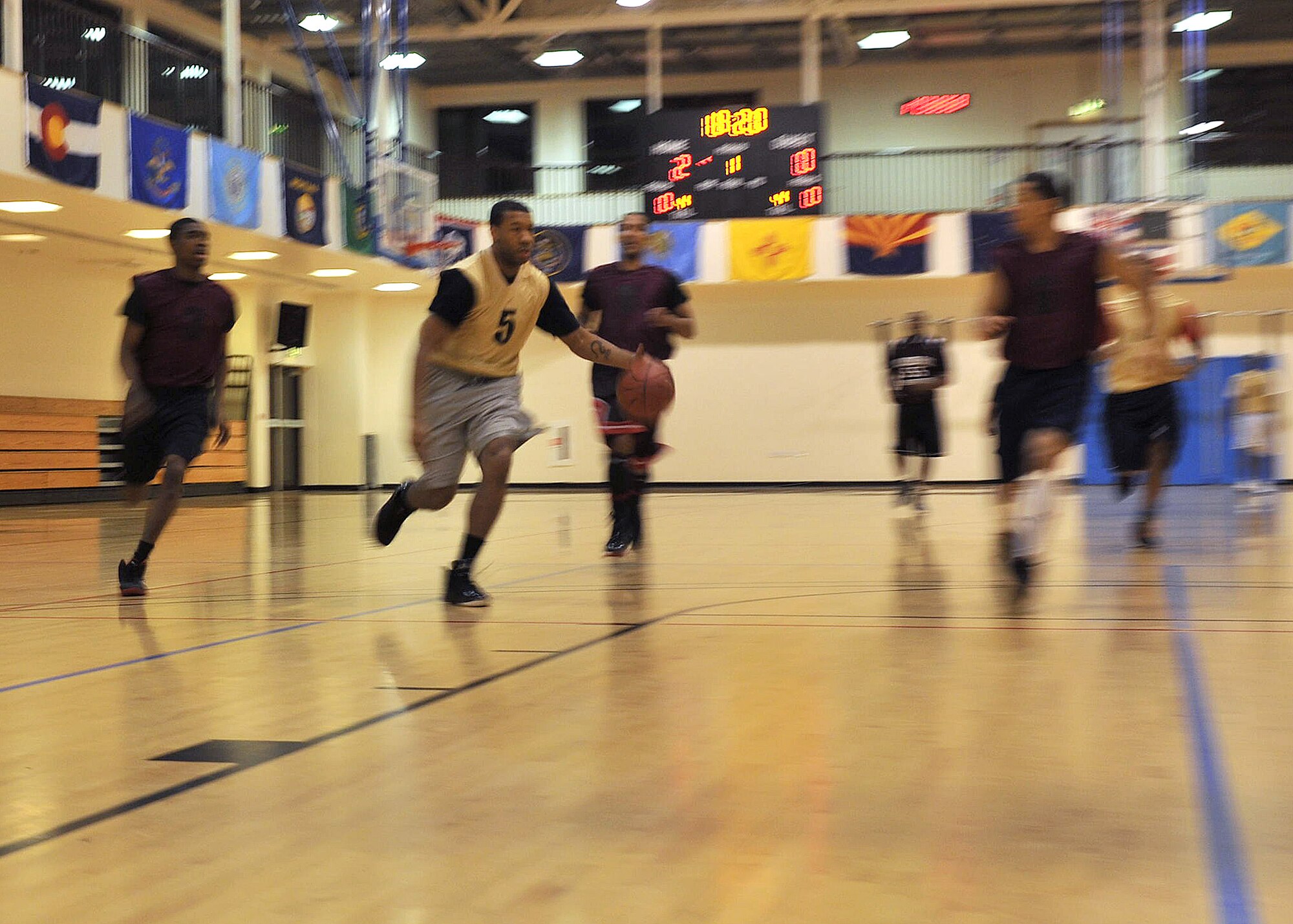 Senior Airman Keith Passmore, 100th Communications Squadron postal worker from Raleigh, N.C., makes his way down the court Dec. 18, 2012, at the Hardstand Fitness Center at RAF Mildenhall, England. The base intramural basketball season kicked off with the 100th CS taking on the 100th Security Forces Squadron. The 100th SFS beat the 100th CS 54-37. (U.S. Air Force photo by Senior Airman Jerilyn Quintanilla/Released)