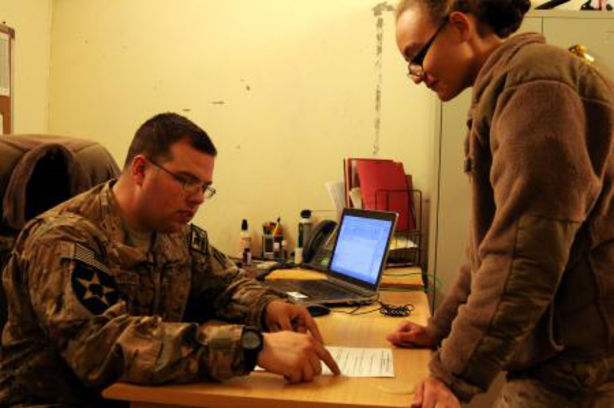 Tech. Sgt. Christopher McDaniel explains an important section of the inprocessing sheet to a visiting member at Forward Operating Base Smart, Afghanistan, Dec. 17,2012. McDaniel is a vehicle operator who was thrust into the head personnel position due to mission needs. The Detroit, Mich. native occasionally has opportunities to return to his combat trucker roots when mission dictates. (U.S. Air Force Photo by Senior Airman Patrice Clarke)




