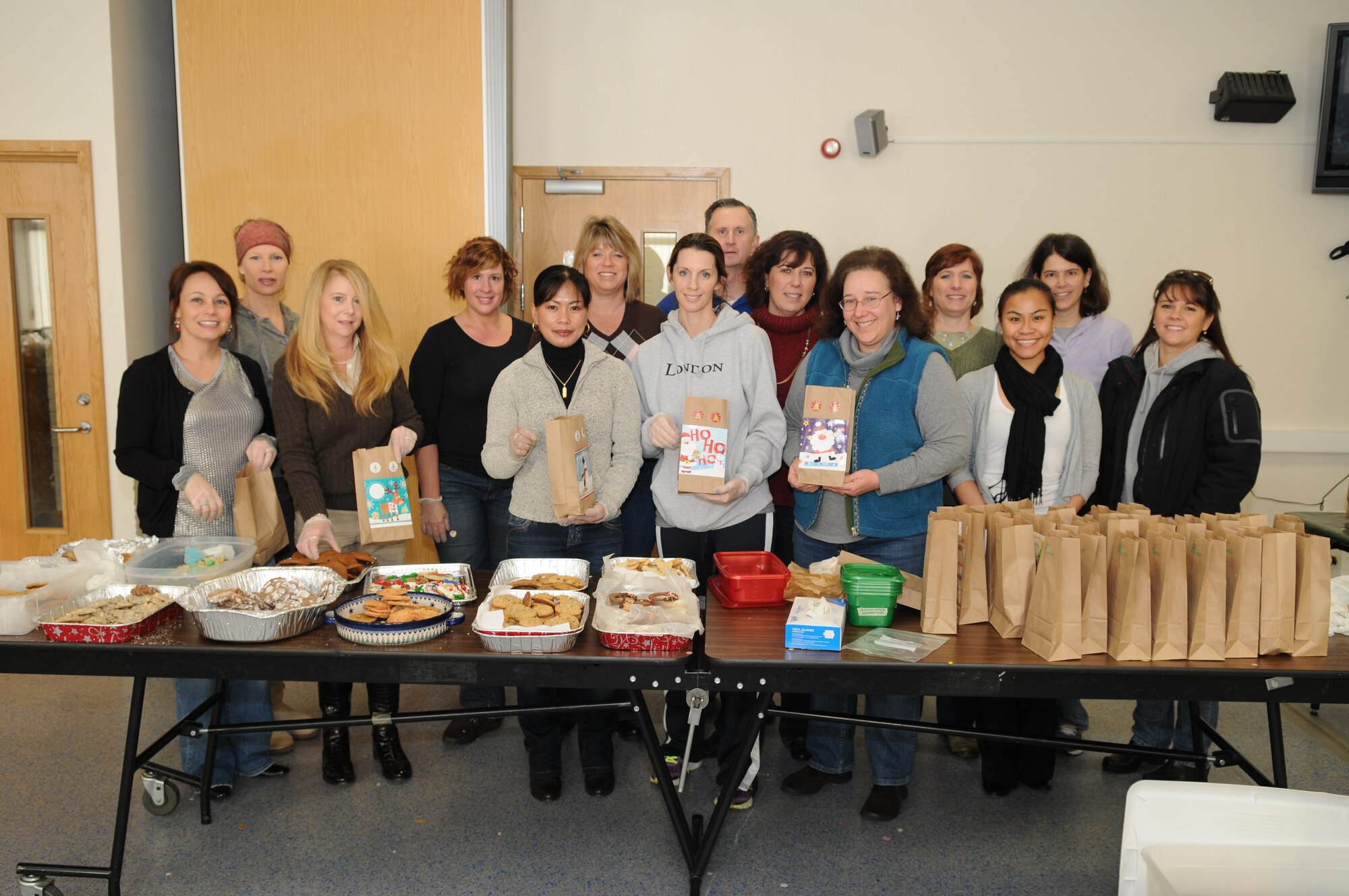 Team Mildenhall volunteers take a break from bagging to pose for a group photo Dec. 18, 2012, at the base chapel, RAF Mildenhall, England.  This is the first year Team Mildenhall donated cookies for the Dorm Dweller Cookie Drive as a whole, instead of individual squadron cookie drives. (U.S. Air Force photo by Airman 1st Class Dillon Johnston/Released)