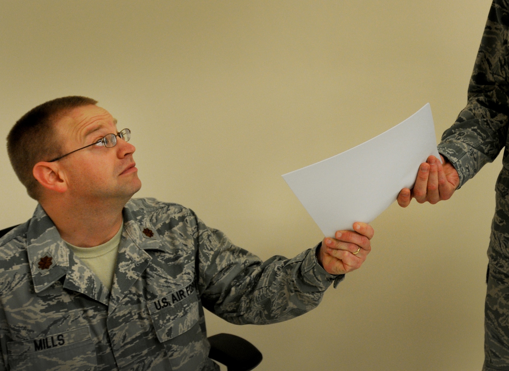 Maj. David Mills, a Combined Air and Space Operations Center Operational Assessment Team analyst, passes information to a coworker at a deployed location in Southwest Asia, Nov. 26. OAT provides information and analysis on everything from weapons systems to surveillance and reconnaissance efforts in support of the CAOC’s strategy division. Mills is a native of San Antonio, Texas. (US Air Force photo/Staff Sgt. Ashley Reed)