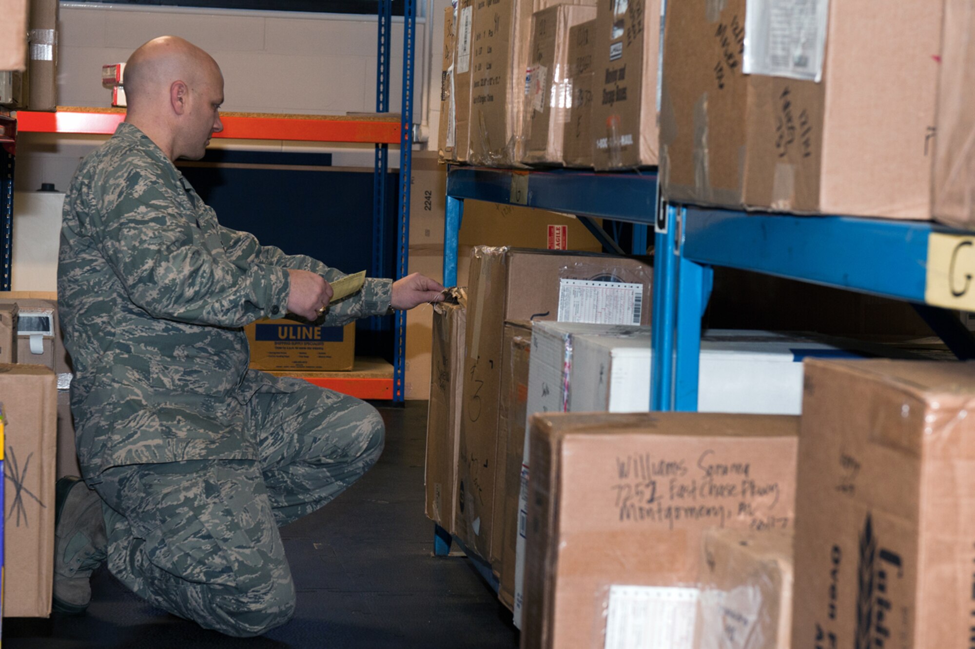 RAF CROUGHTON, United Kingdom – Col. Brian May, 501st Combat Support Wing vice commander, looks for a package for a customer at the RAF Croughton Post Office Dec. 17. The 501st CSW leadership team were just a few of the volunteers to help the post office teams during the holiday rush of packages. (U.S. Air Force photo by Staff Sgt. Brian Stives)