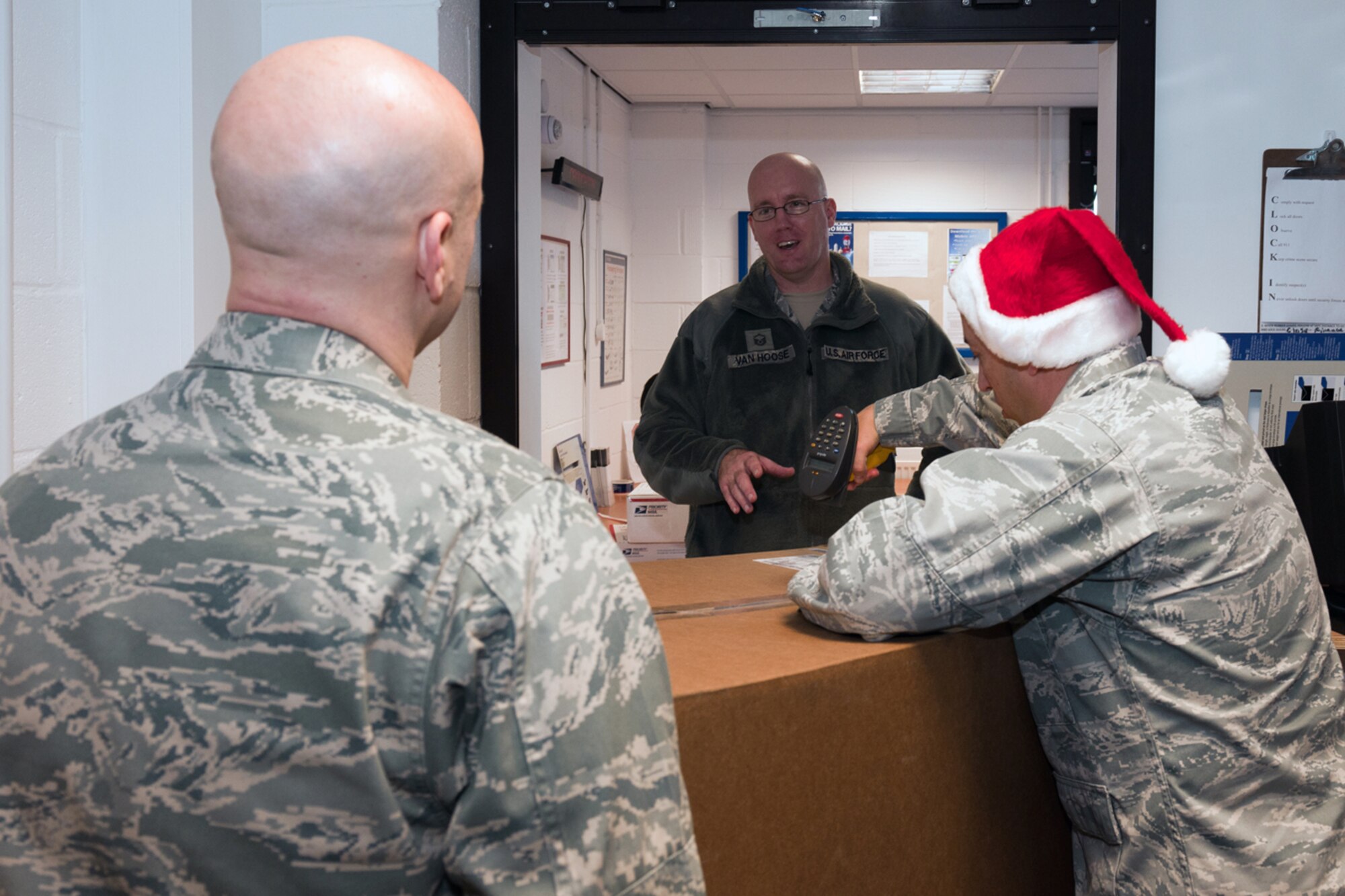 RAF CROUGHTON, United Kingdom – Col. Brian Kelly, 501st Combat Support Wing commander, and Col. Brian May, 501st CSW vice commander, deliver a package to Master Sgt. Brian Van Hoose, 422nd Security Forces Squadron, at the RAF Croughton Post Office Dec. 17. The 501st CSW leadership team were just a few of the volunteers to help the post office teams during the holiday rush of packages. (U.S. Air Force photo by Staff Sgt. Brian Stives)